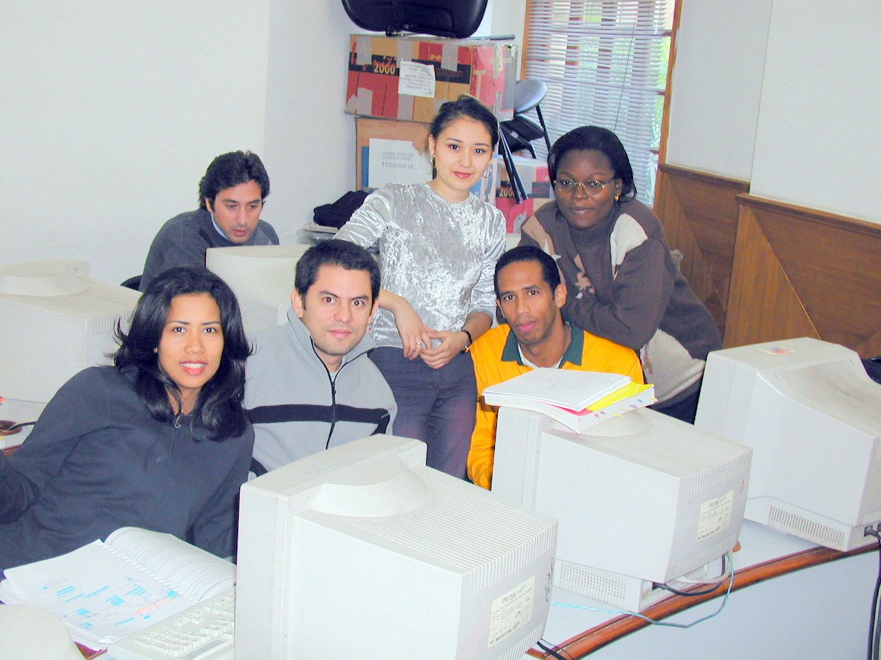 Compañeros reunidos frente a varias computadoras.