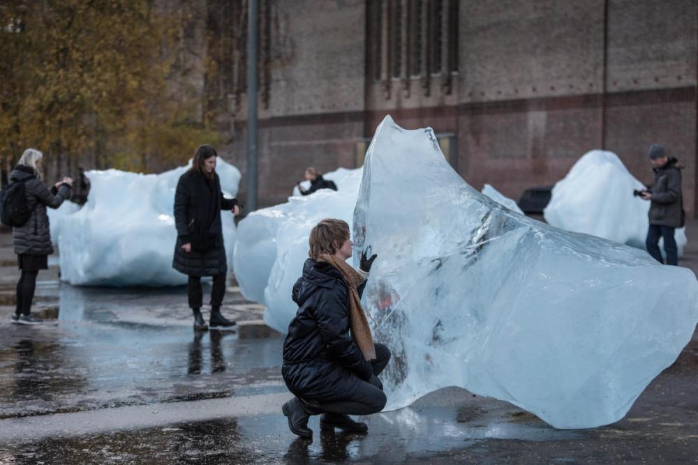 An image of a woman staring at an iceberg. 