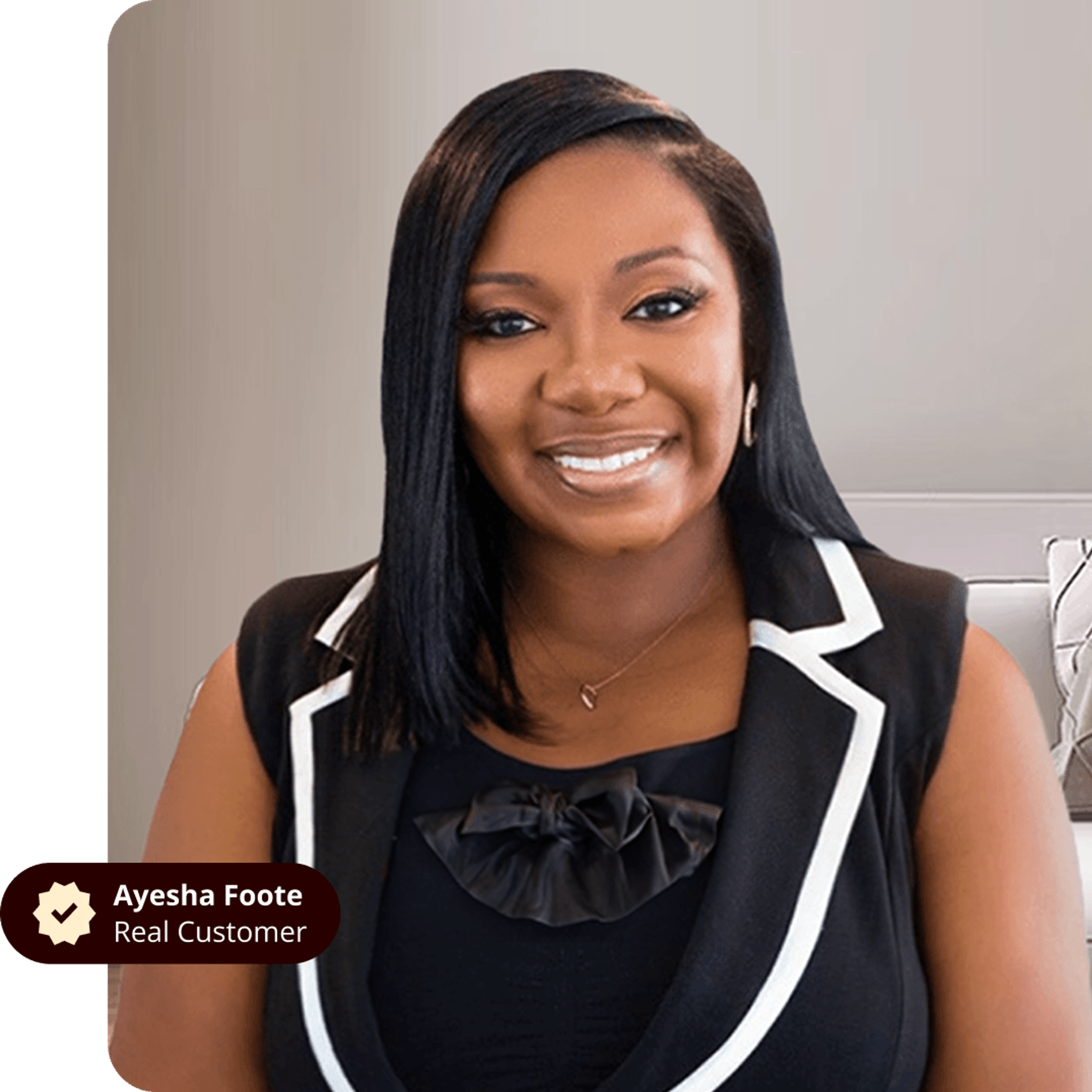 Ayesha Foote, a real customer, smiling in a black top with white lapels.