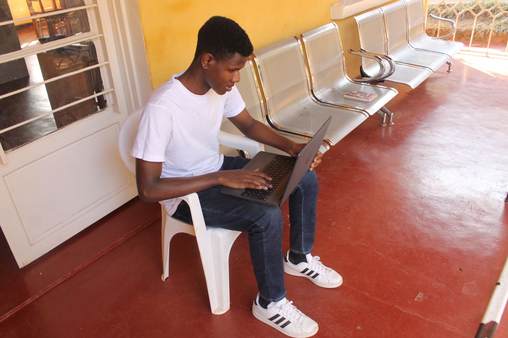 Idrissa studying on his laptop