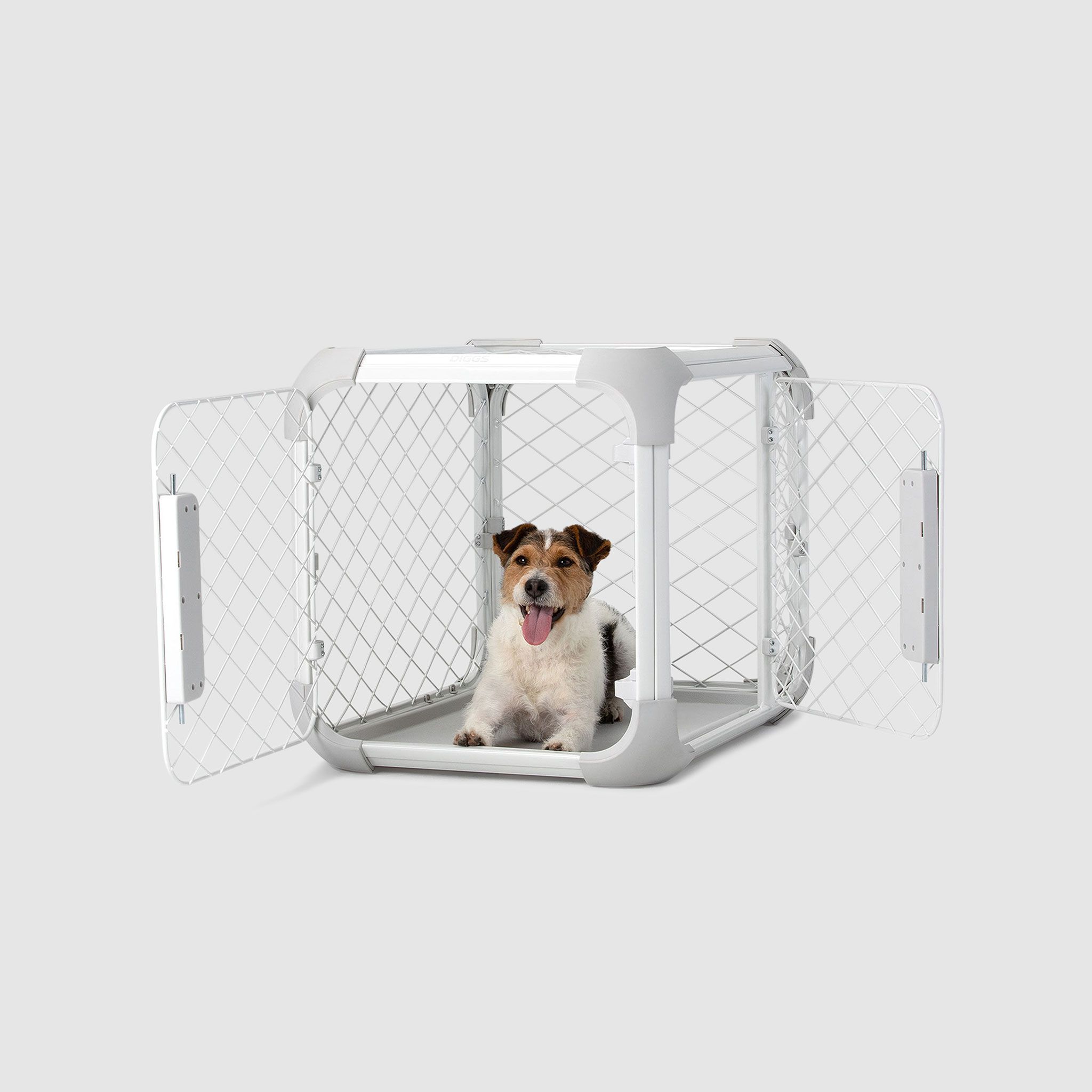 A dog sitting inside of a white dog crate