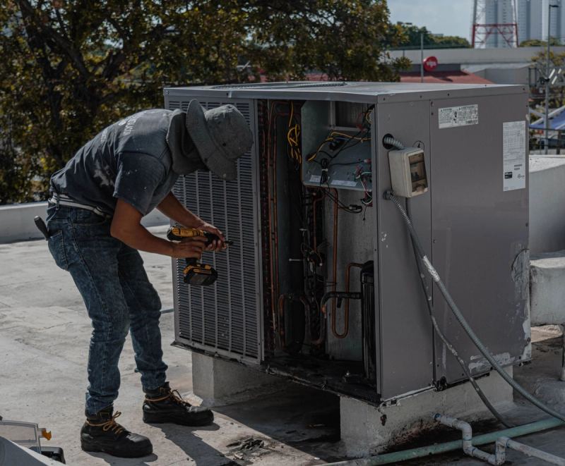 Teknisi membersihkan unit indoor AC — service ac sharp
