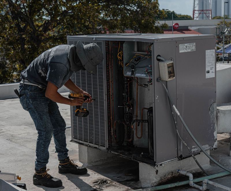 Teknisi membersihkan unit indoor AC — service ac sharp