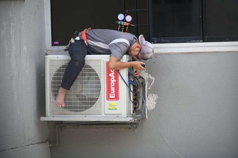 Teknisi membersihkan unit indoor AC — harga pasang ac 1/2 pk