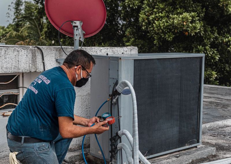 Teknisi membersihkan unit indoor AC — jasa bongkar pasang ac