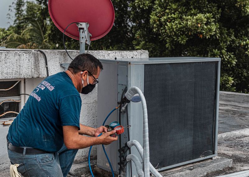 Teknisi membersihkan unit indoor AC — jasa bongkar pasang ac