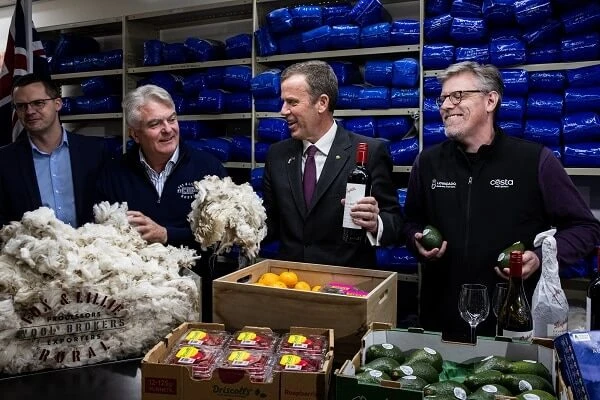 Minister for Trade, Tourism and Investment Dan Tehan (second right) holds wool and a bottle of wine during a press conference about the signing of the trade agreement with India, in Melbourne. (Source: AAP)