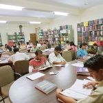 Students reading at library tables