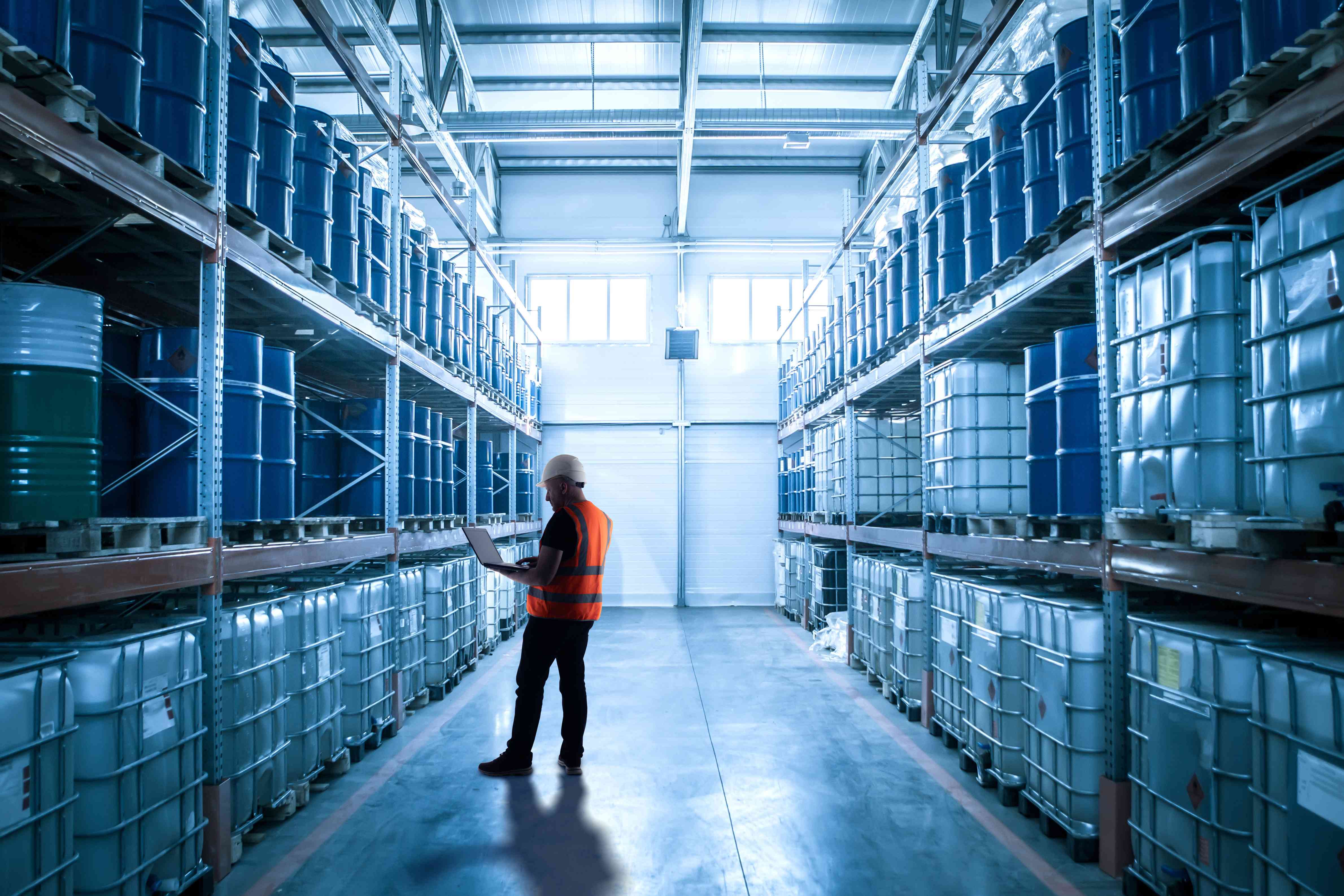 Image of a man in a warehouse stocked with IBC totes and steel drums