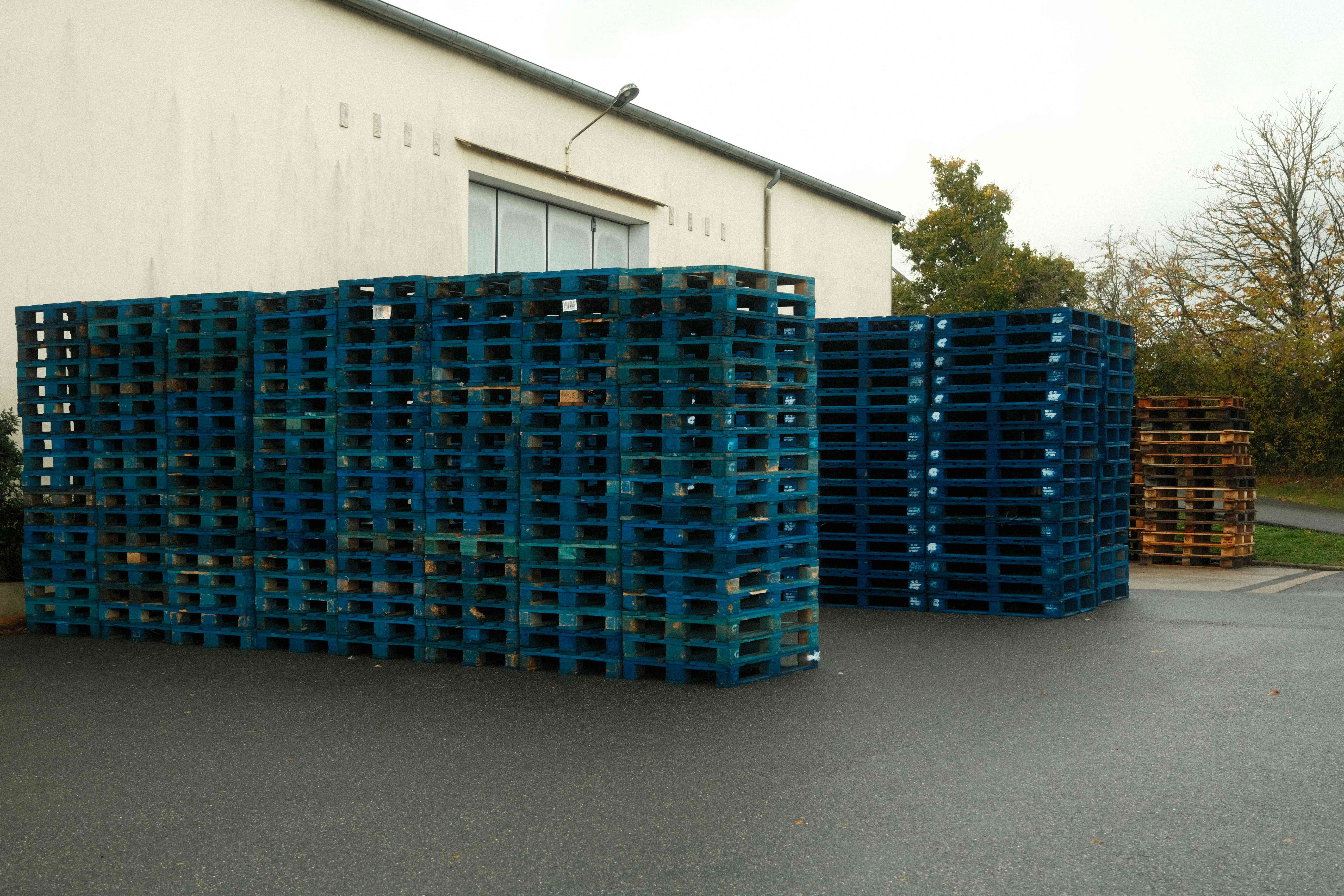 Stacked new plastic pallets in a warehouse