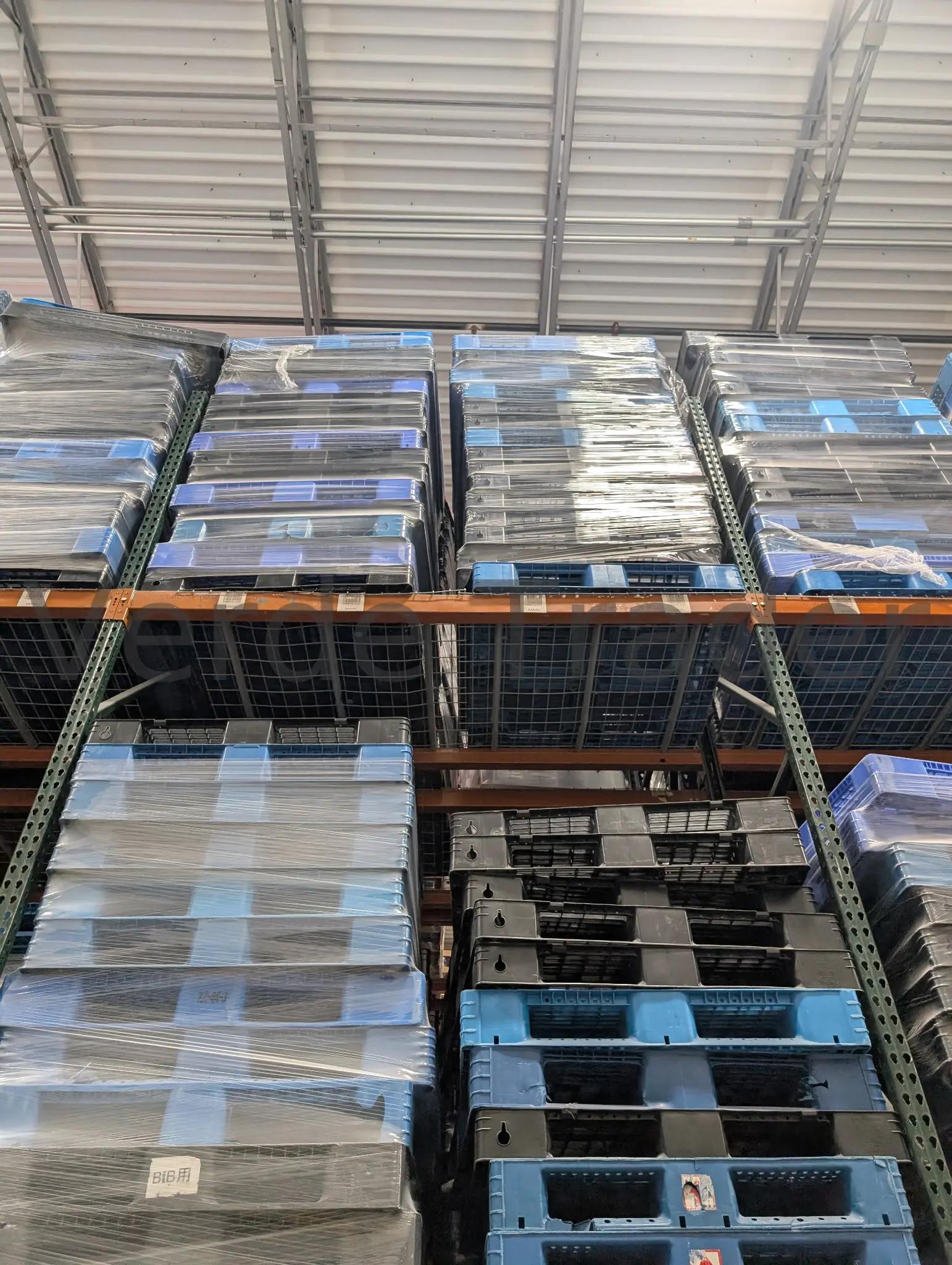 Rackable plastic pallets stored on warehouse beam rack shelving