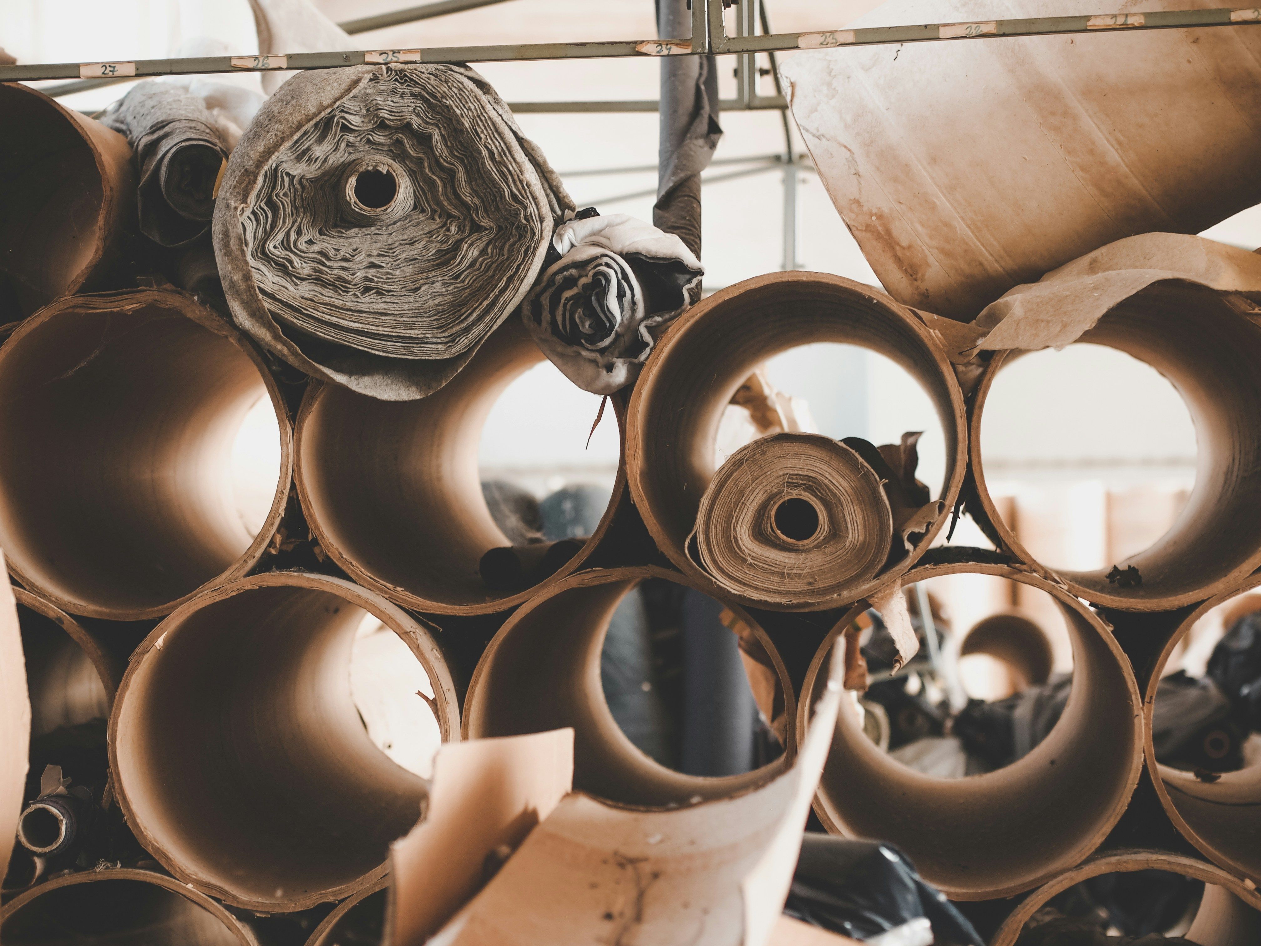 Palletized stack of fiber drums in a warehouse aisle