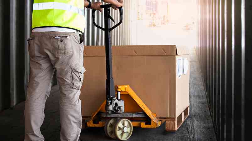 man pushing a Gaylord on a pallet jack in a truck
