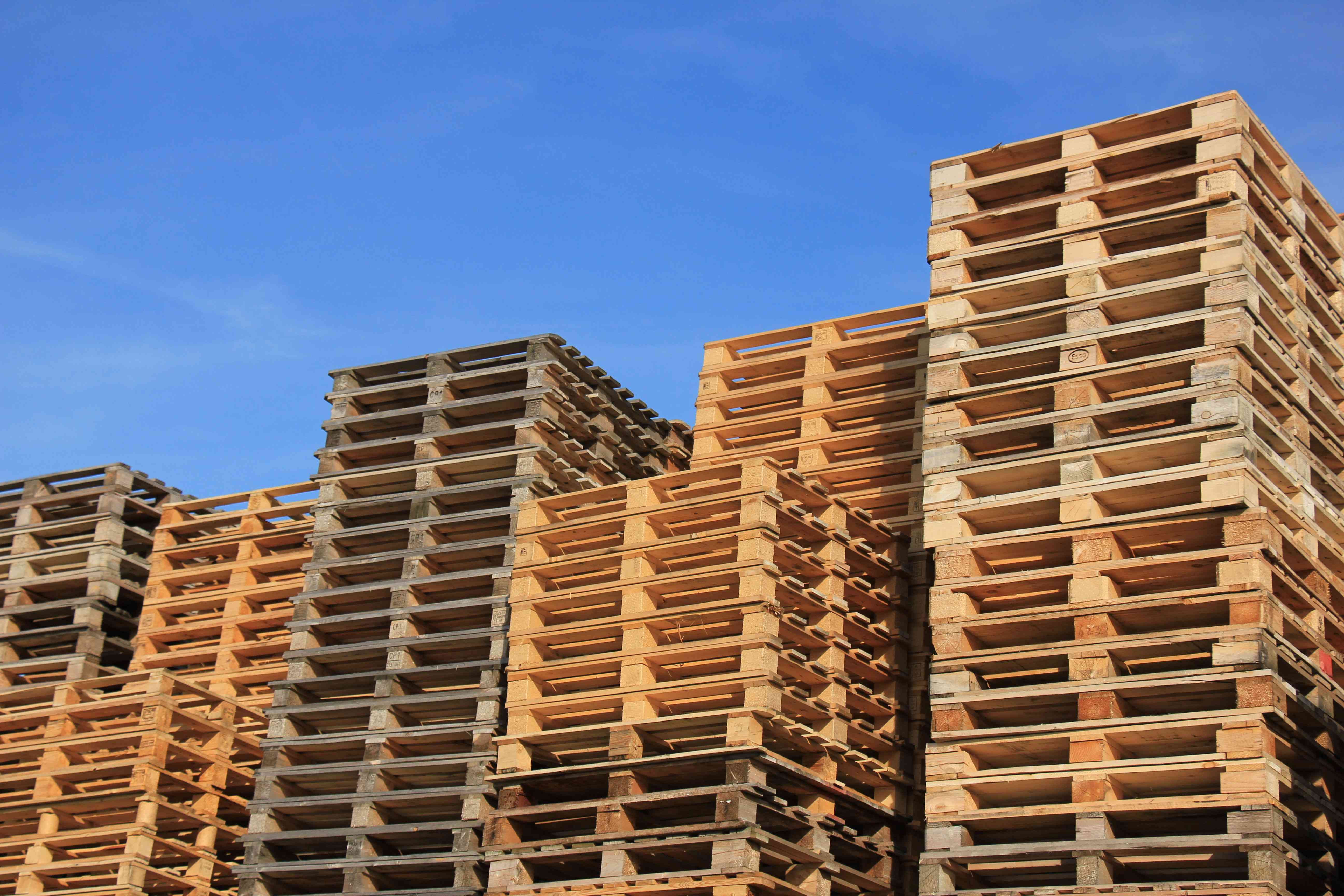 A photo of stacks of block wood pallets