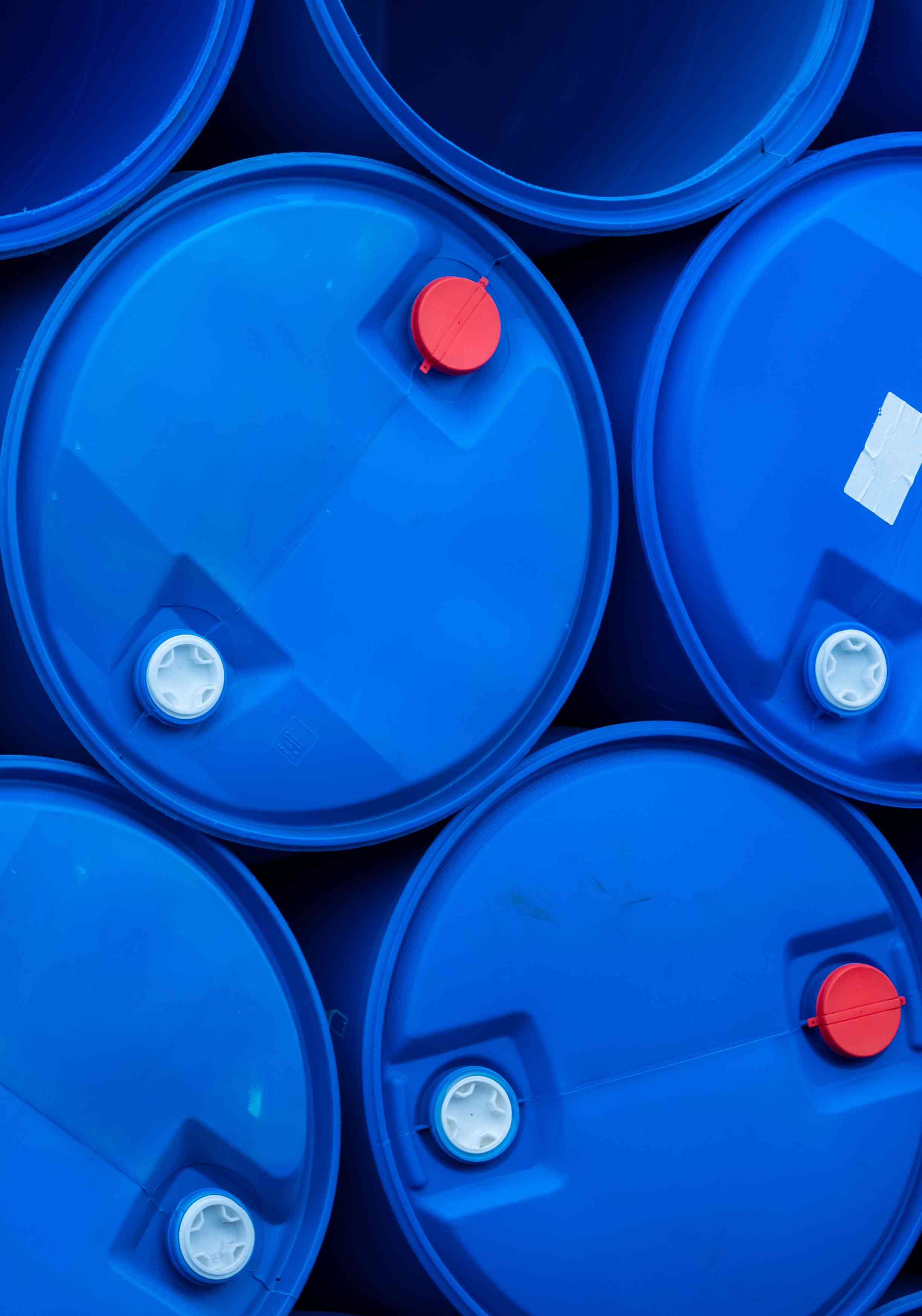 Photo of plastic drums stacked on their sides