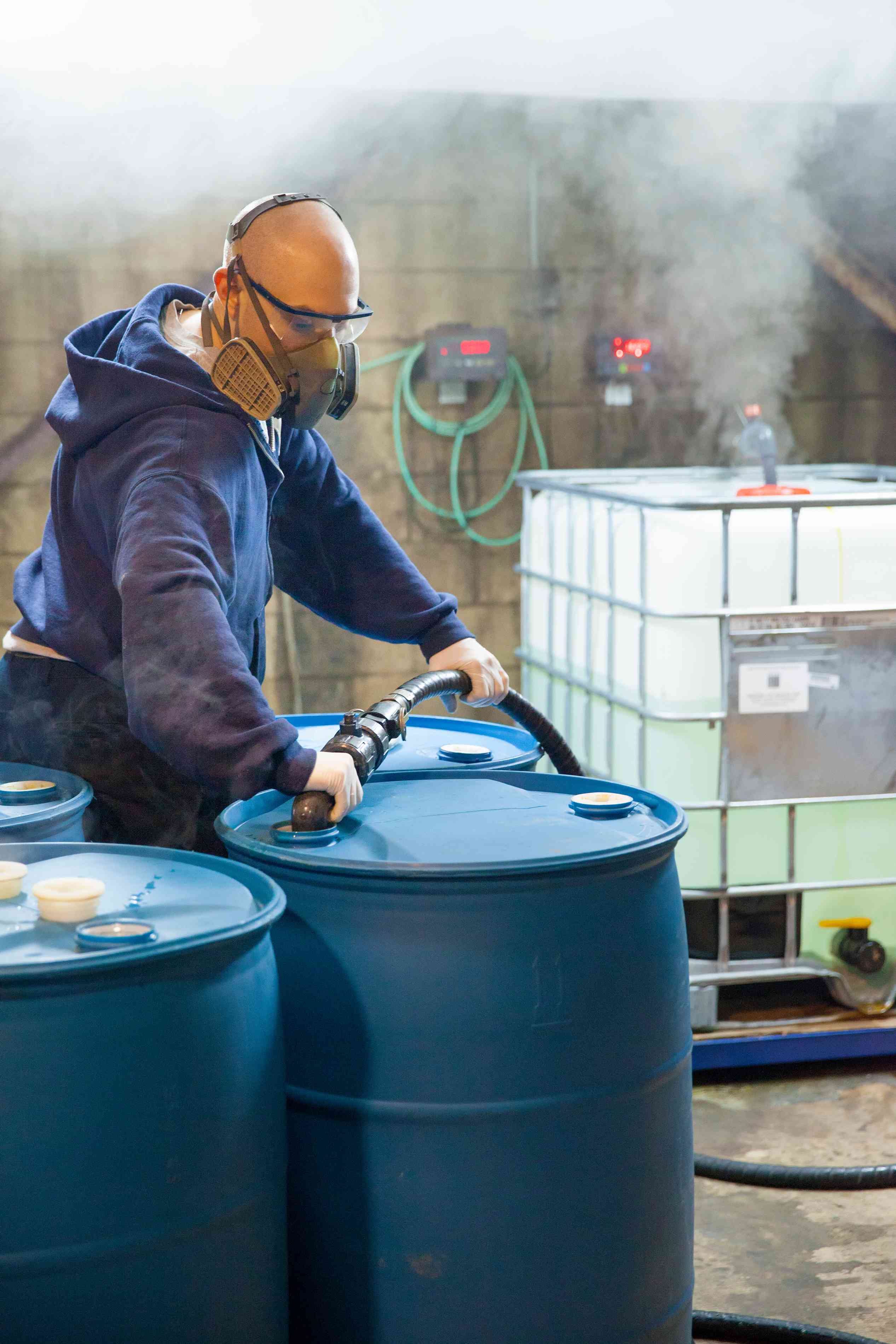 Photo of a factory worker filling a plastic drum