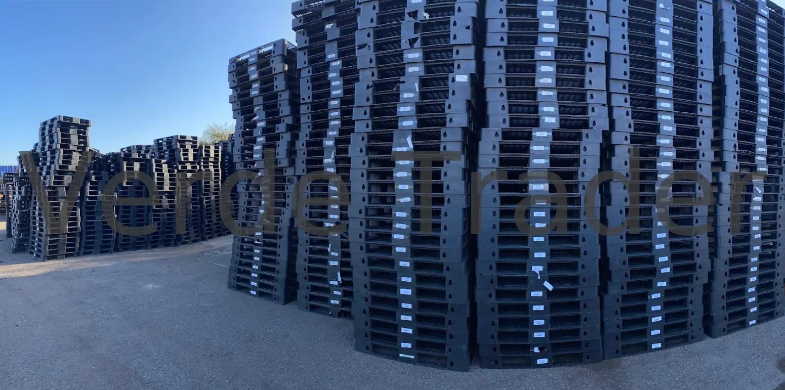 Plastic pallets block stacked on a warehouse floor in multiple columns