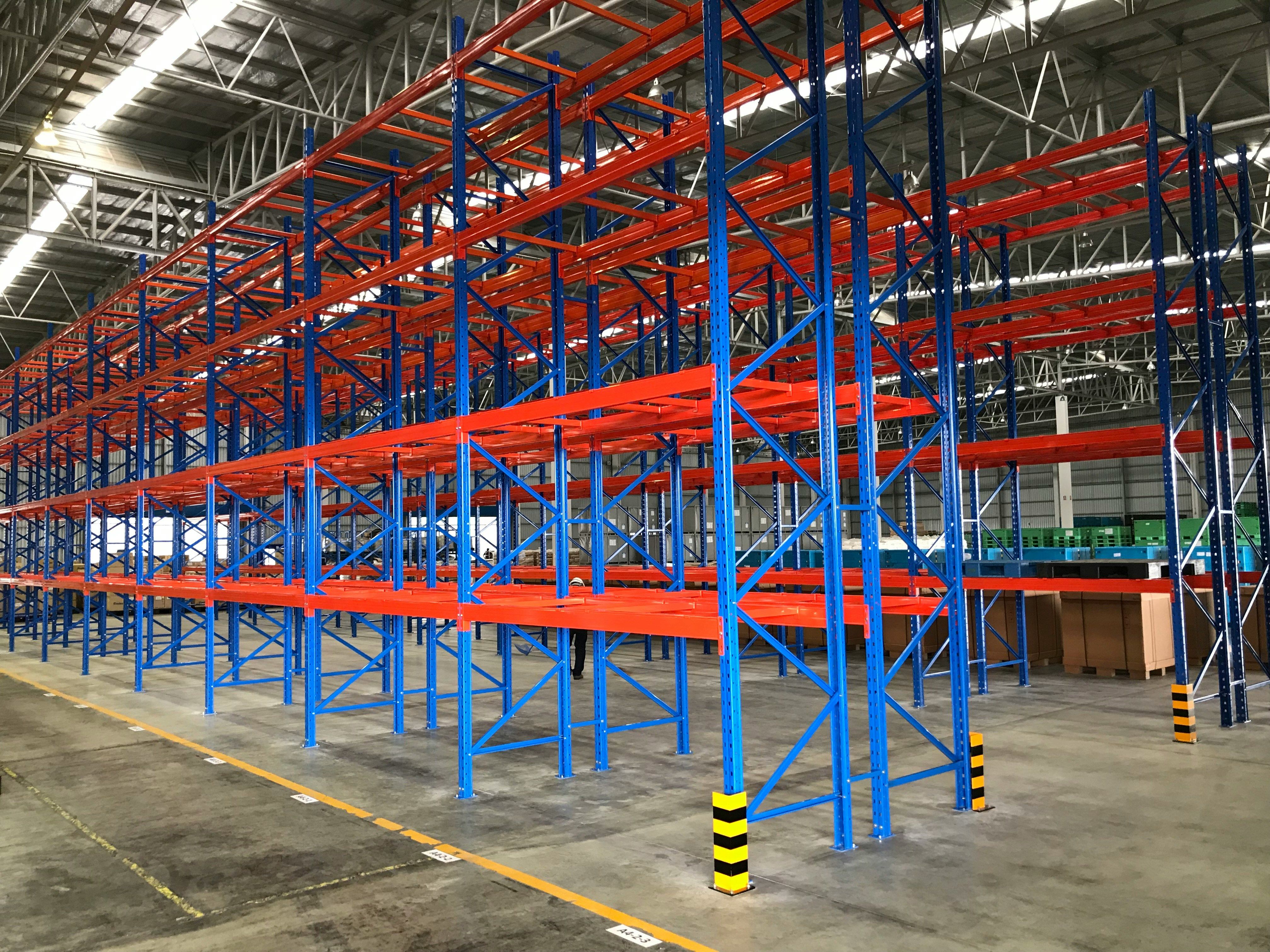 Rackable plastic pallet loaded on two beam rails in a warehouse rack, showing unsupported span beneath