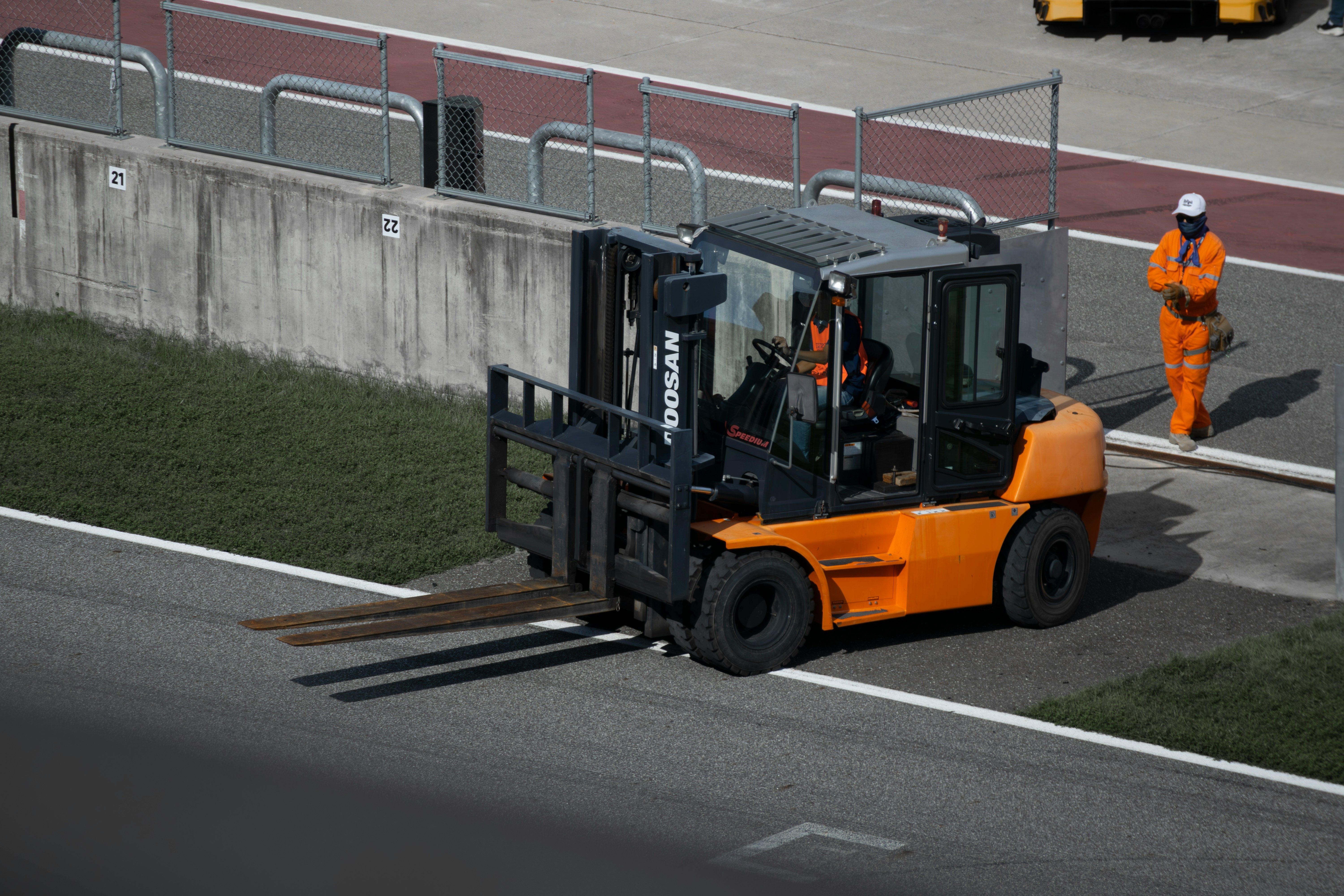 Forklift moving loaded nestable plastic pallets in a distribution center