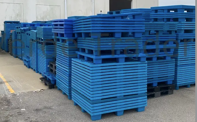 Empty nestable plastic pallets nested inside one another in a compressed stack