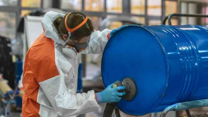 man working on a steel drum in a factory