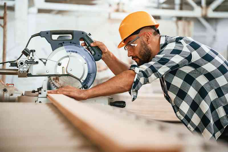man sawing lumber