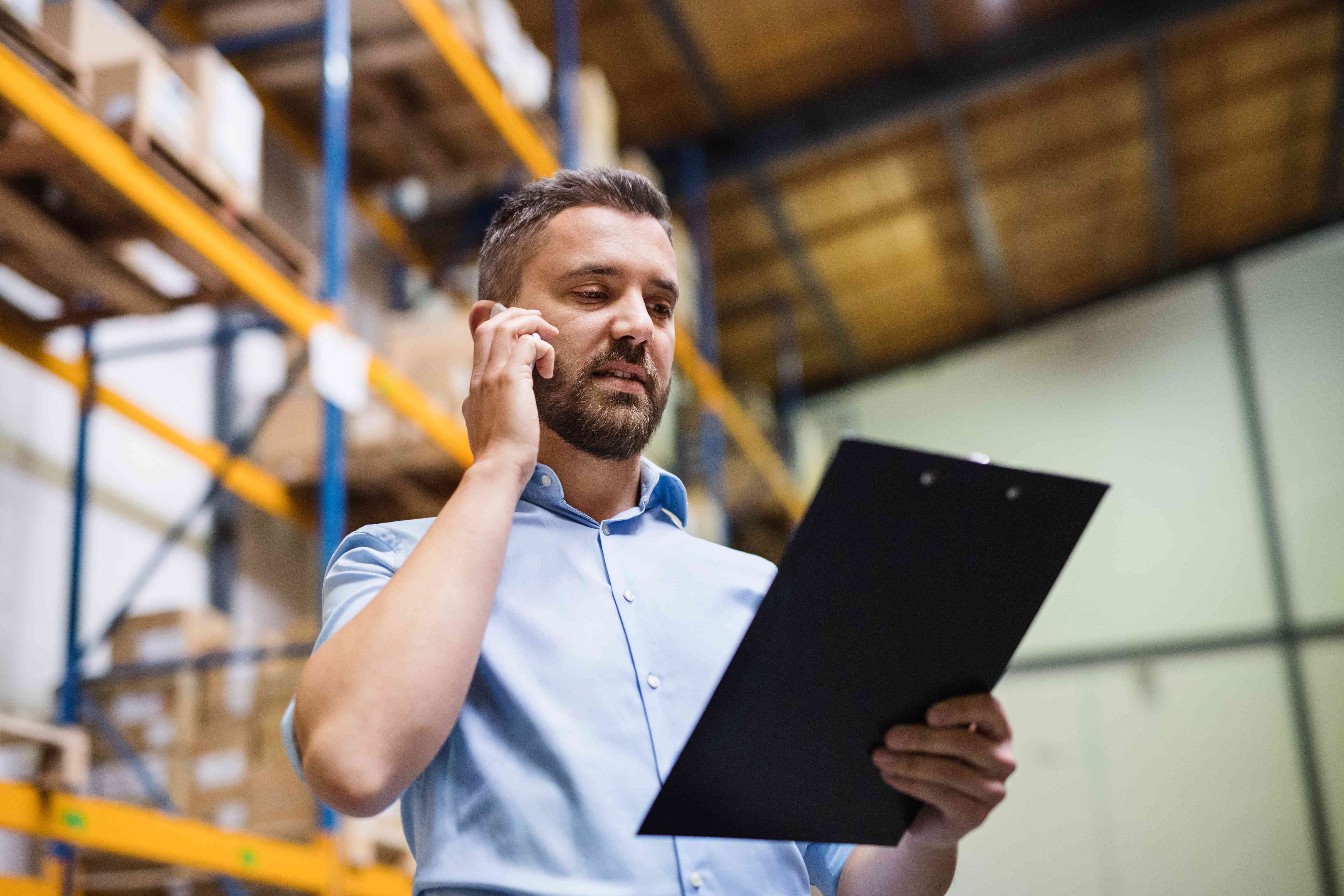 Photo of a man in a warehouse talking on a phone