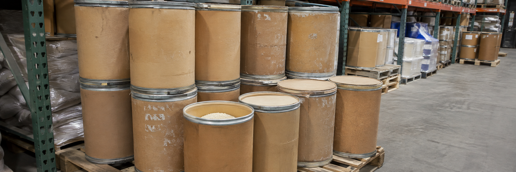 Used fiber drums stacked in a warehouse holding dry industrial goods