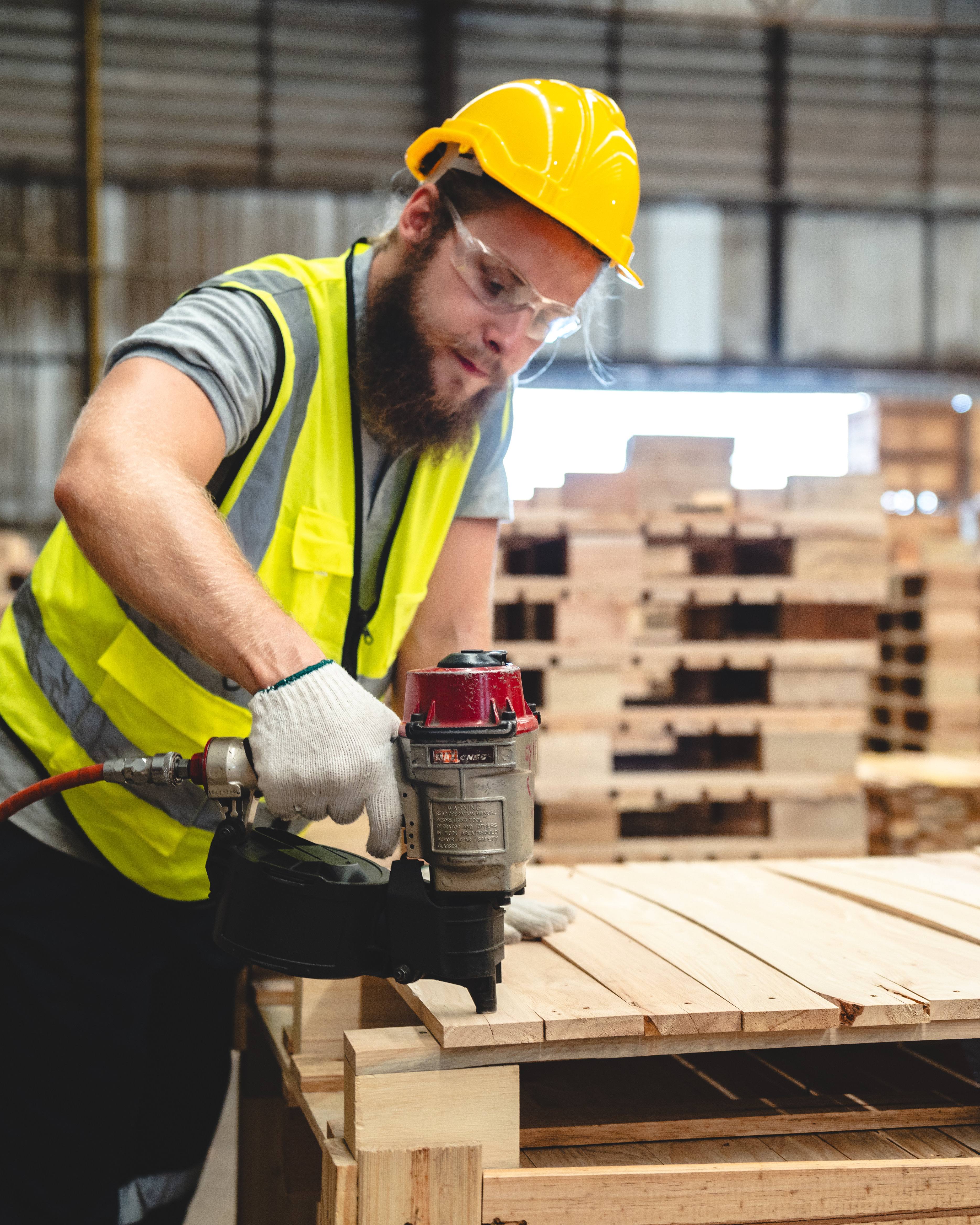 Photo of a man constructing wood pallets