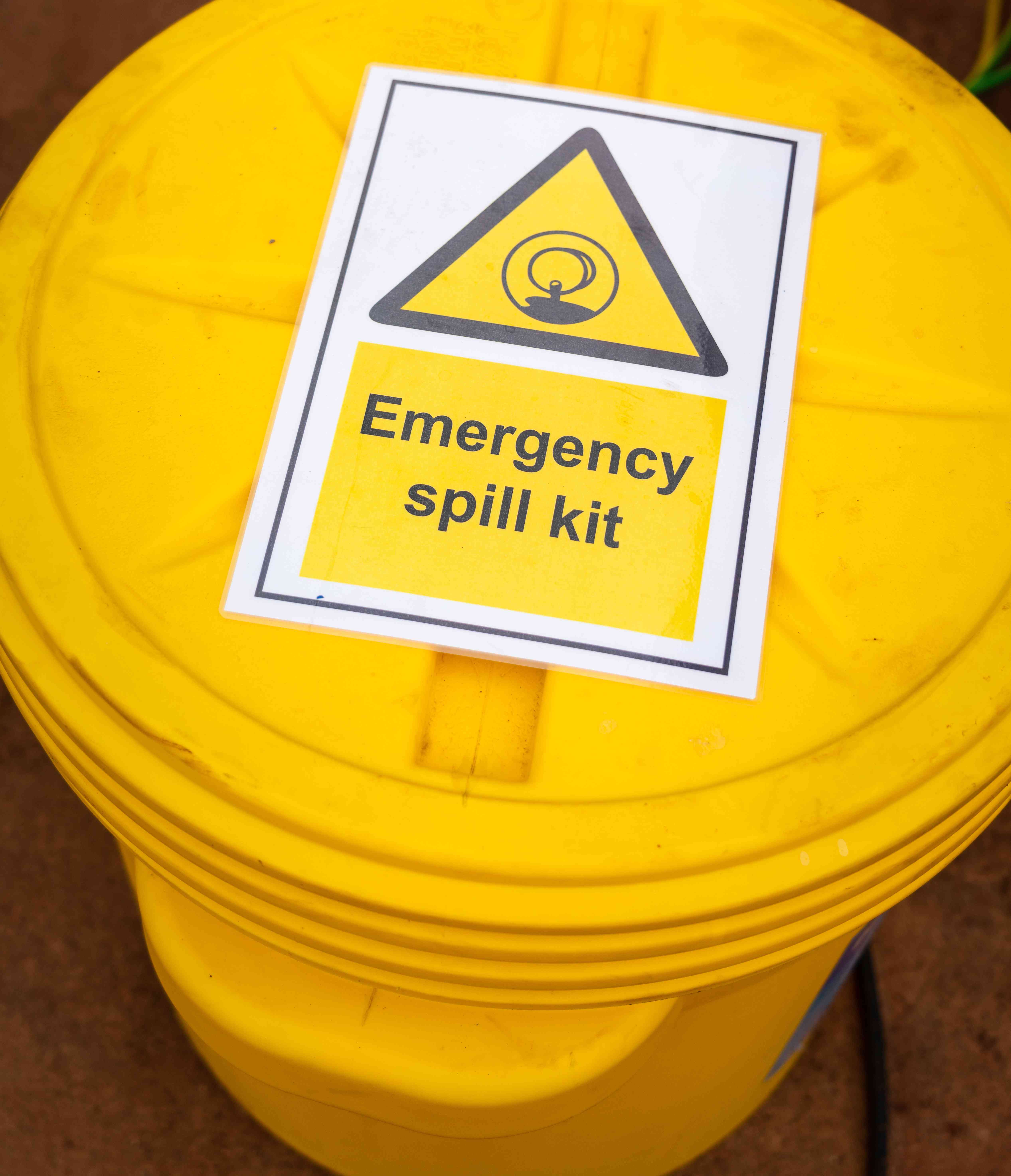 Photo of a yellow, lab pack plastic drum labeled "emergency spill kit"