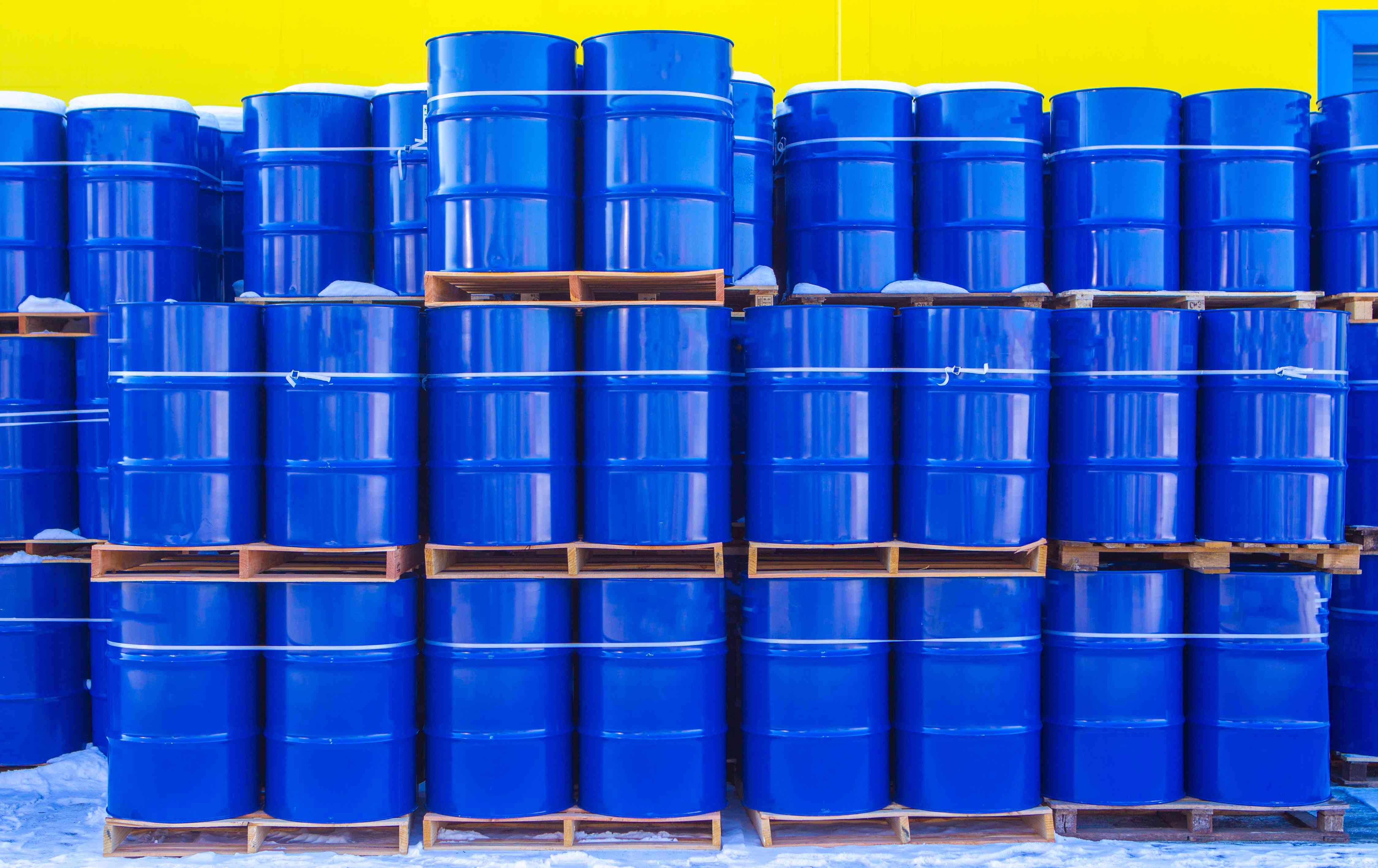 Photo of stacks of blue steel drums on pallets