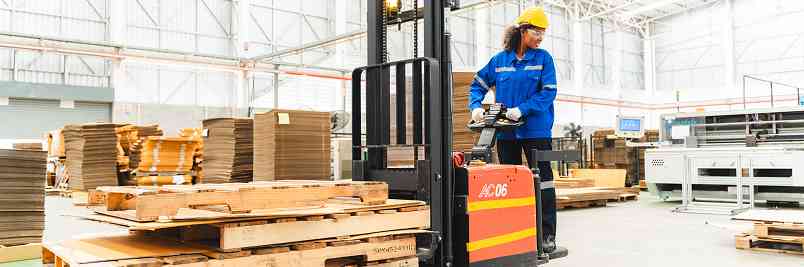 woman using a forklift to move pallets