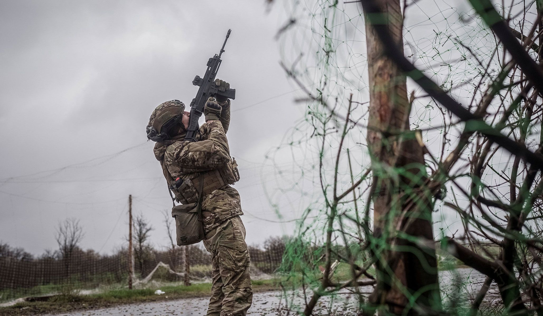 A serviceman of the 24th Separate Mechanized Brigade of the Ukrainian Armed Forces fires an assault rifle to shoot down a Russian drone during a mission to protect streets in the frontline town of Druzhkivka, Donetsk Region, Ukraine, April 24, 2026.