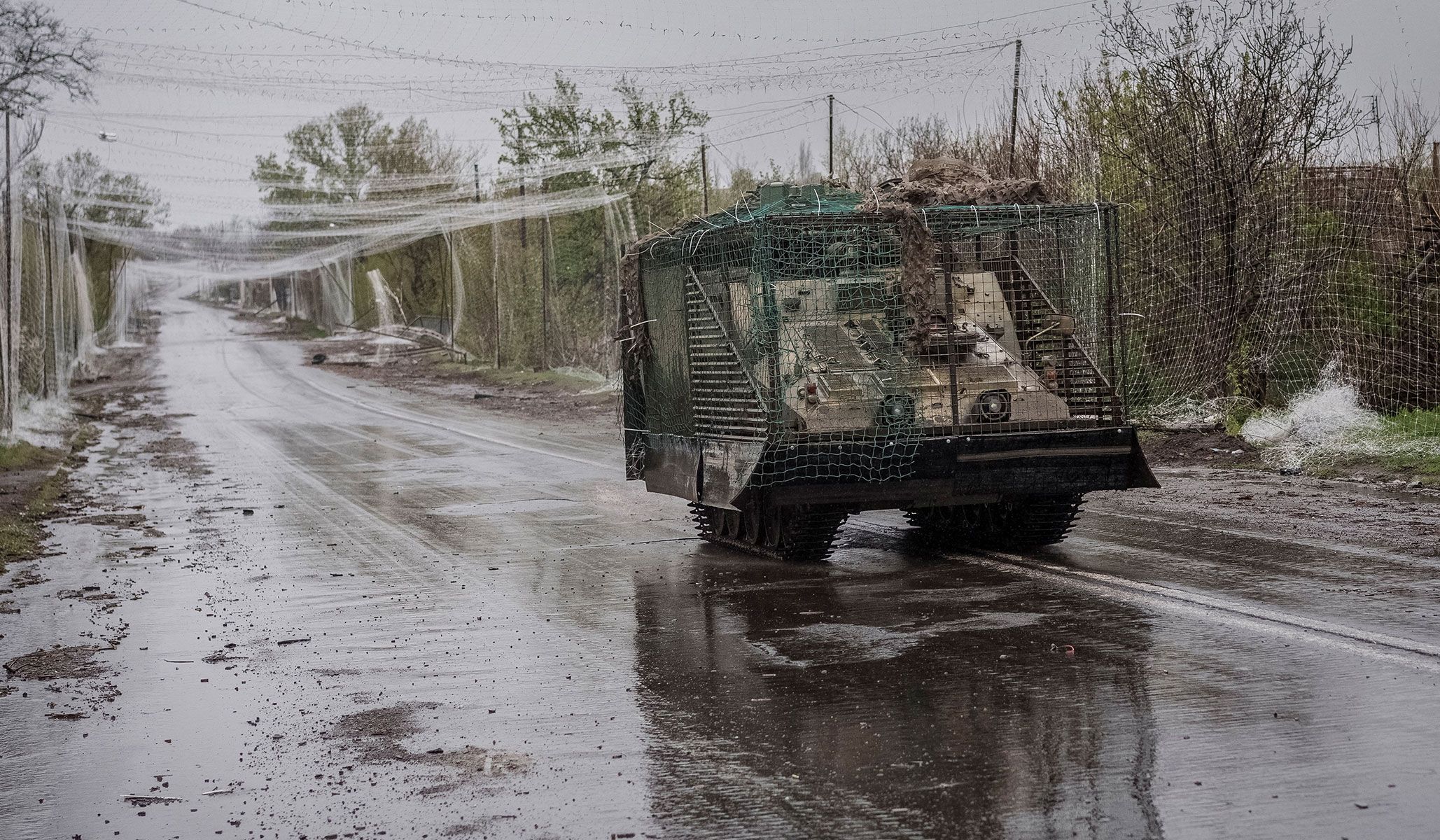 A military vehicle drives along a road covered with anti-drone net in the frontline town of Druzhkivka, Donetsk Region, Ukraine, April 24, 2026.