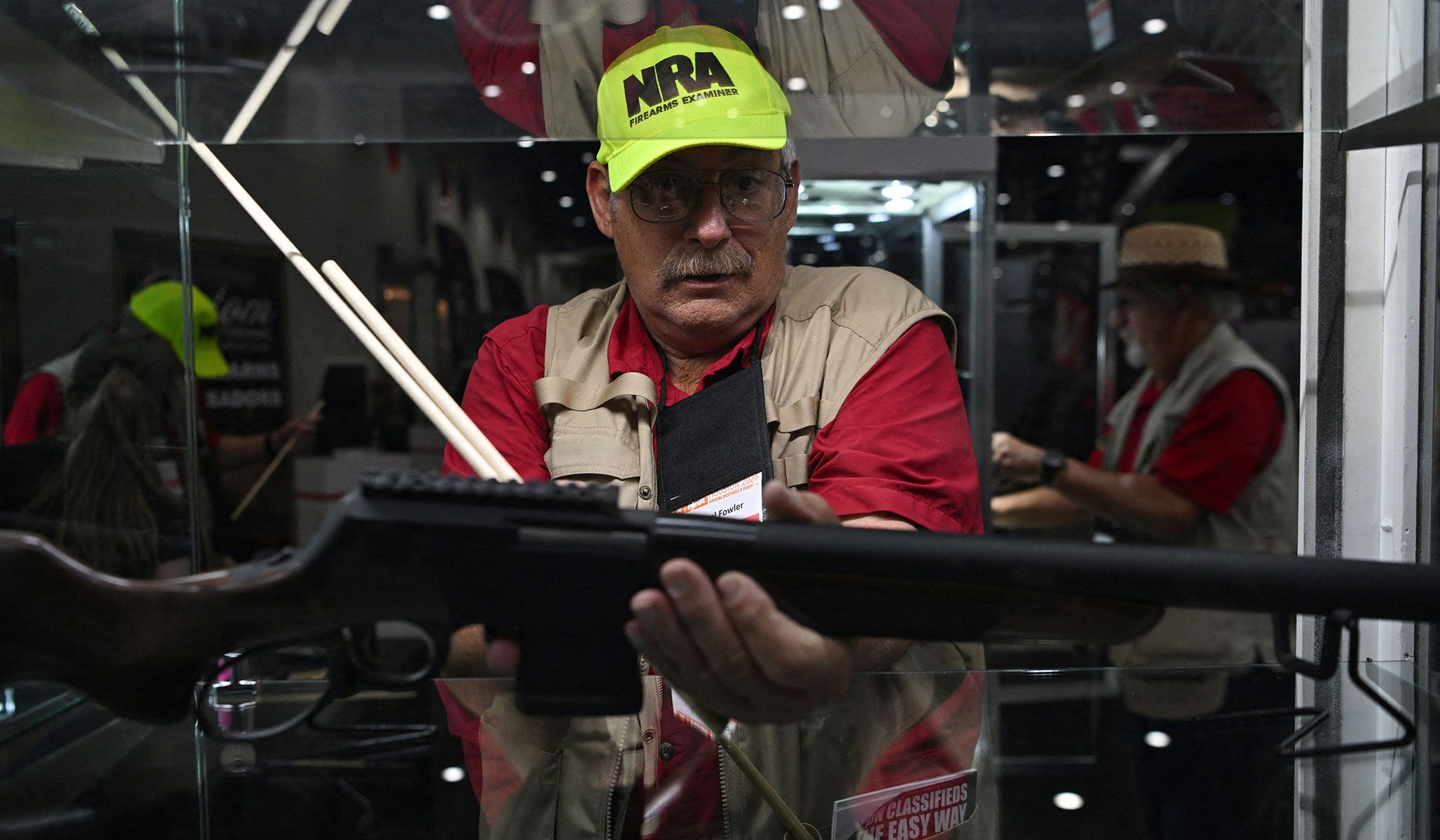 An NRA firearms examiner inspects a gun to ensure it is unloaded as exhibitors set up booths ahead of the National Rifle Association's annual meetings and exhibits in Houston, Texas, April 16, 2026.