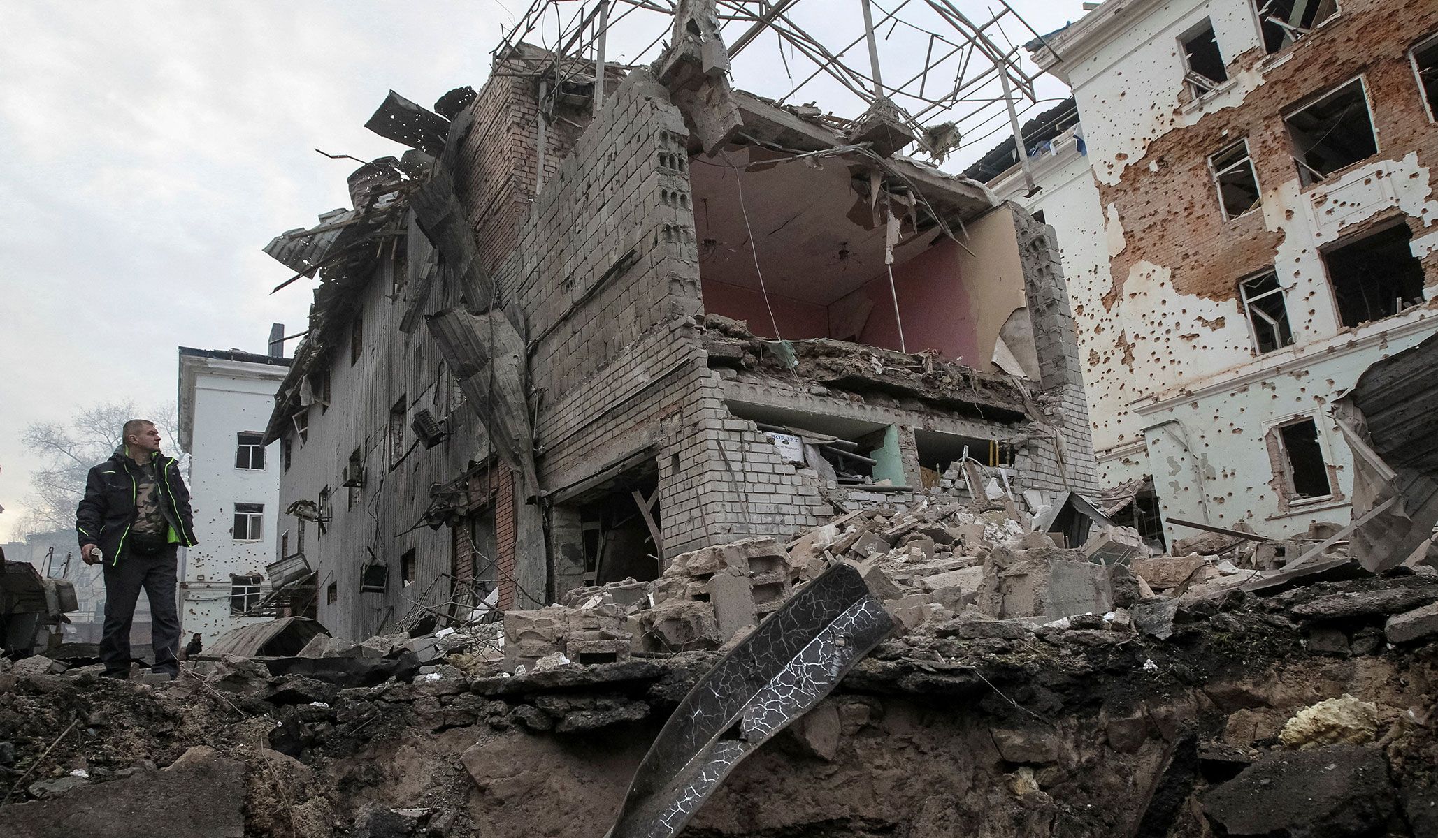 A resident stands near apartment buildings hit by a Russian missile and drone strike in Dnipro, Ukraine, April 16, 2026.