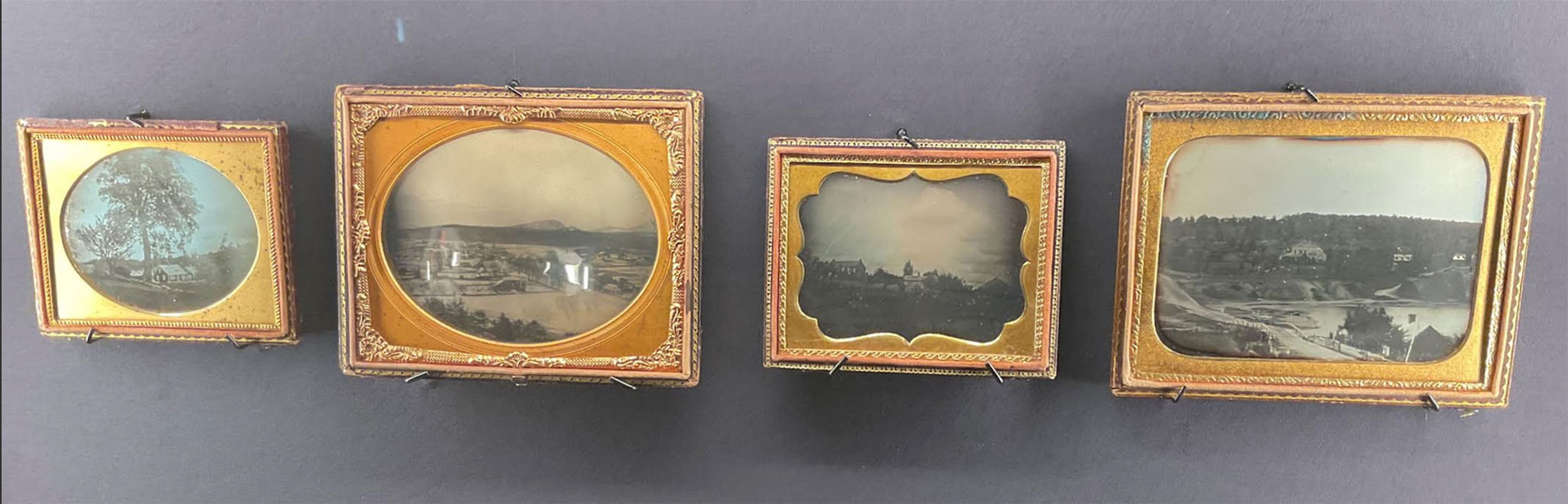 Early experiments include a close-up look at trees and a distant house, bird’s-eye views, and cloud studies. View of a daguerreotype case in the gallery.
