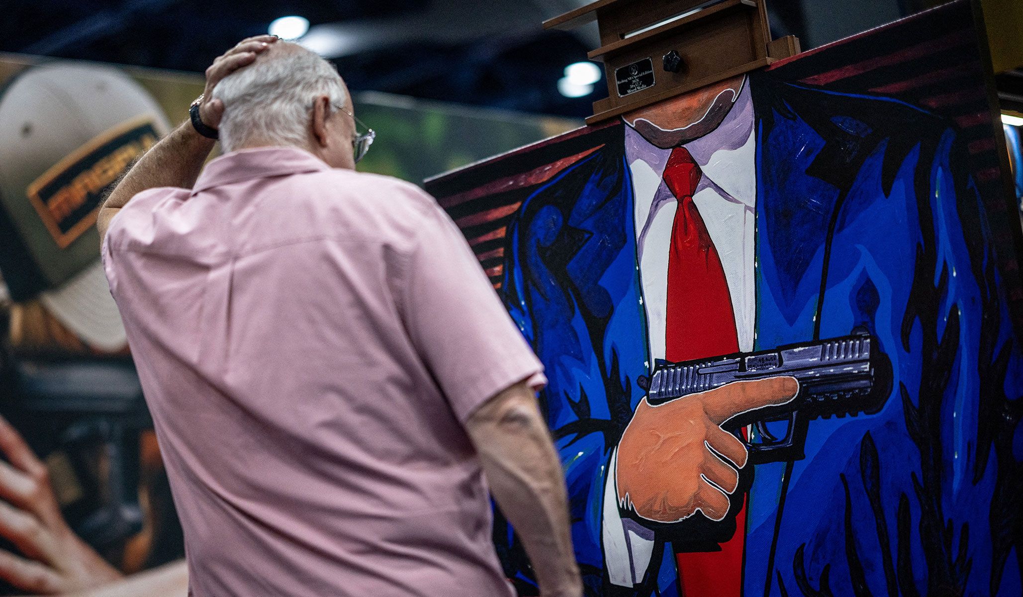 A man pauses to look at a painting during the National Rifle Association's annual meetings and exhibits in Houston, Texas, April 17, 2026.