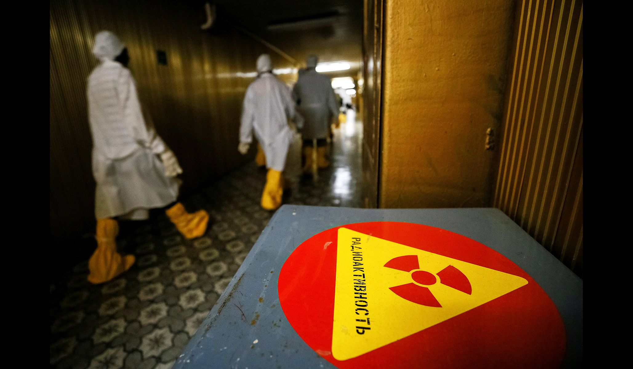 Journalists walk through the corridor of the stopped third reactor at the Chernobyl nuclear power plant in Chernobyl, Ukraine, April 20, 2018.