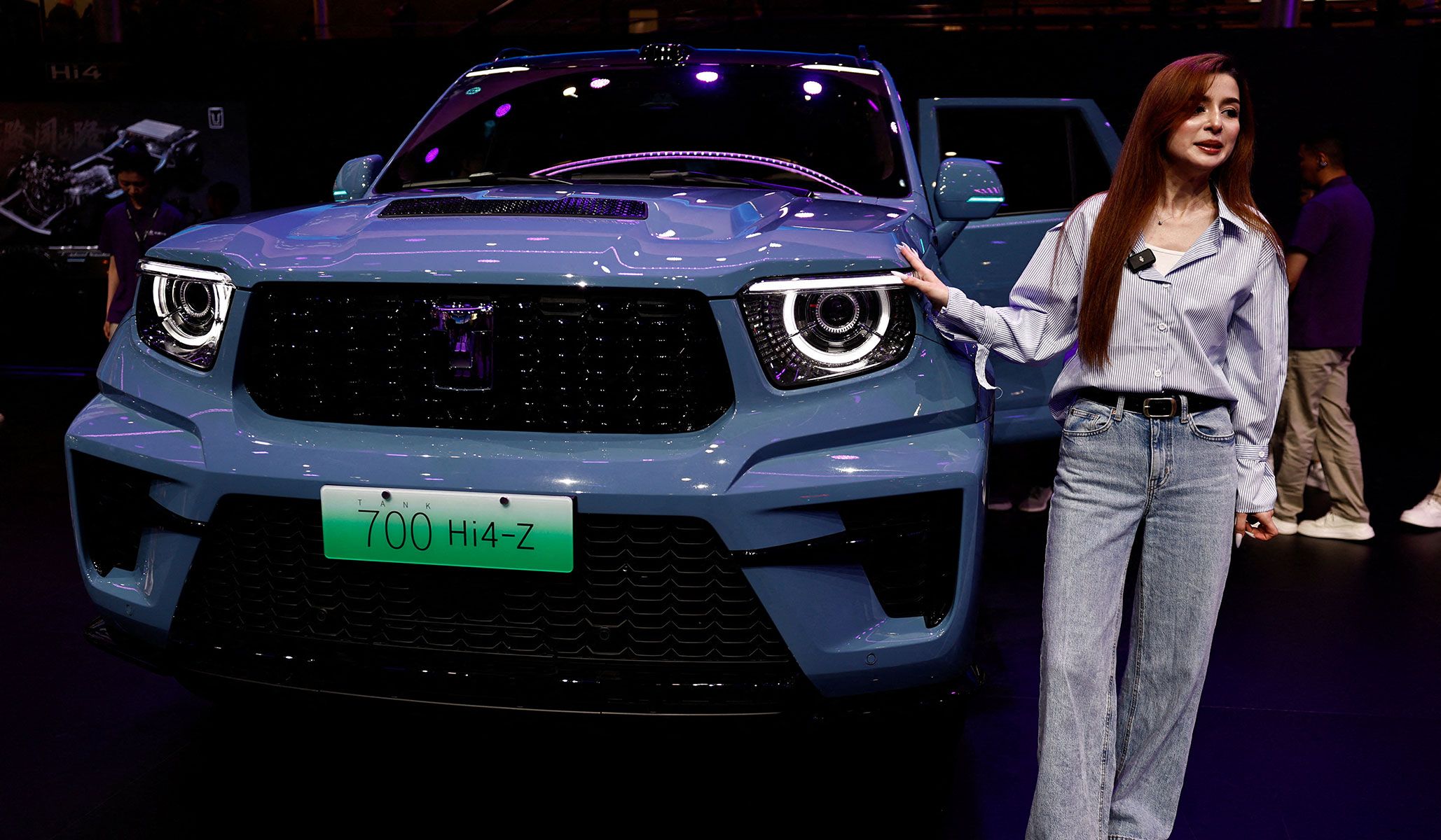 A woman poses during a filming session to promote the Great Wall Motors Tank 700 Hi4-Z at the Beijing International Automotive Exhibition in Beijing, China, April 24, 2026.