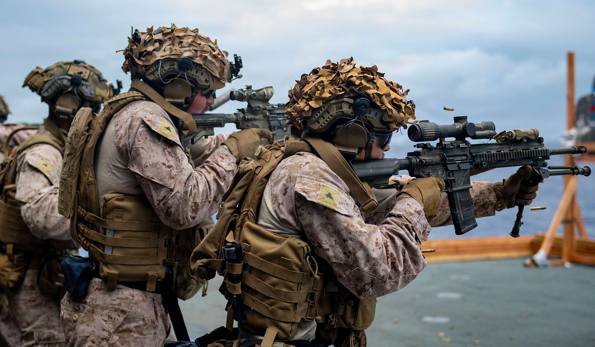 U.S. Marines assigned to Battalion Landing Team 3/5, 11th Marine Expeditionary Unit, fire M4 carbines during marksmanship training in the hangar bay of the Wasp-class amphibious assault ship USS <i>Boxer</i> (LHD-4), under way in the U.S. Seventh Fleet area of operations, April 13, 2026.