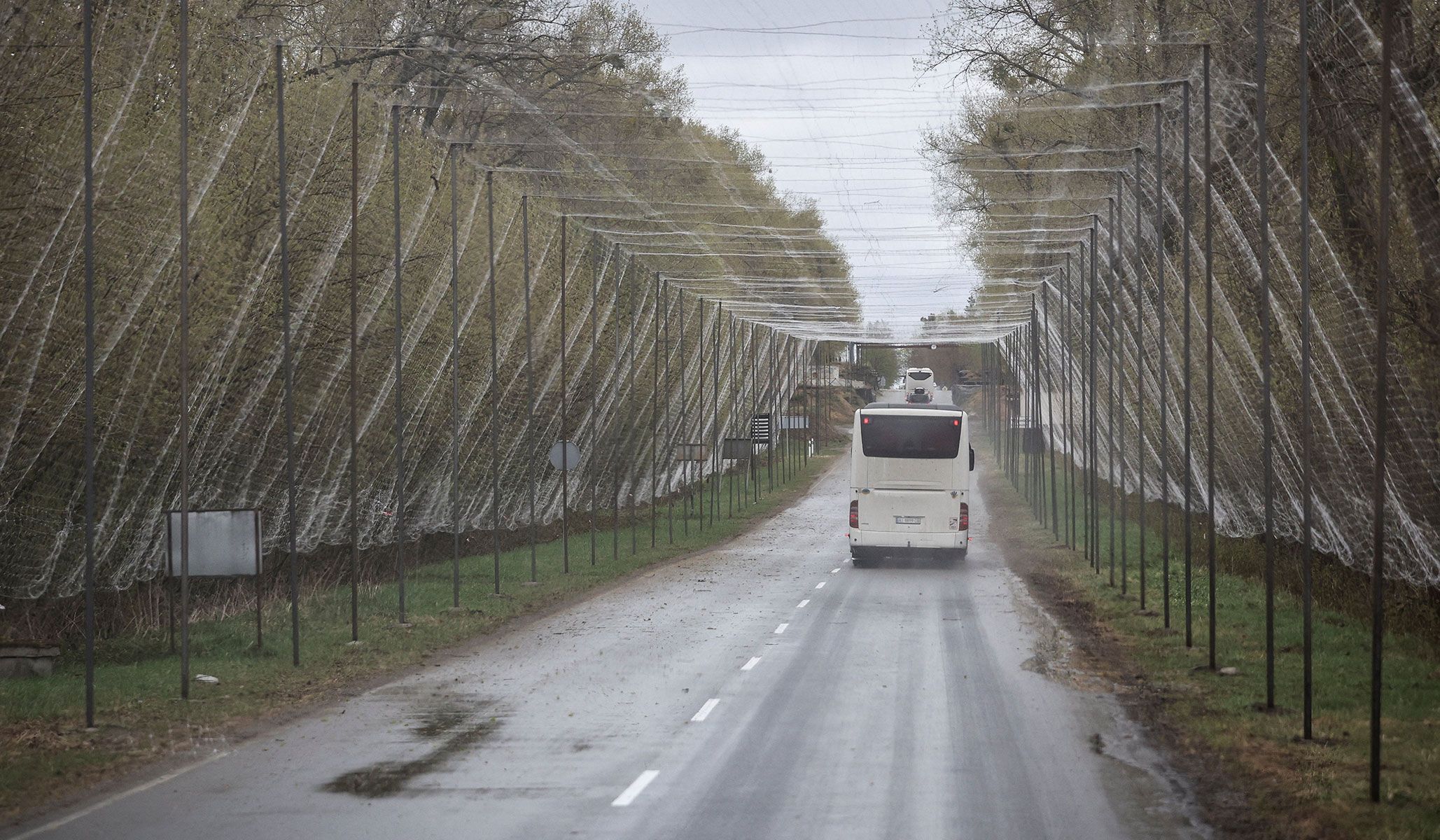 A bus drives on a road covered with anti-drone net near the Chornobyl Nuclear Power Plant in Kyiv Region, Ukraine, April 26, 2026.