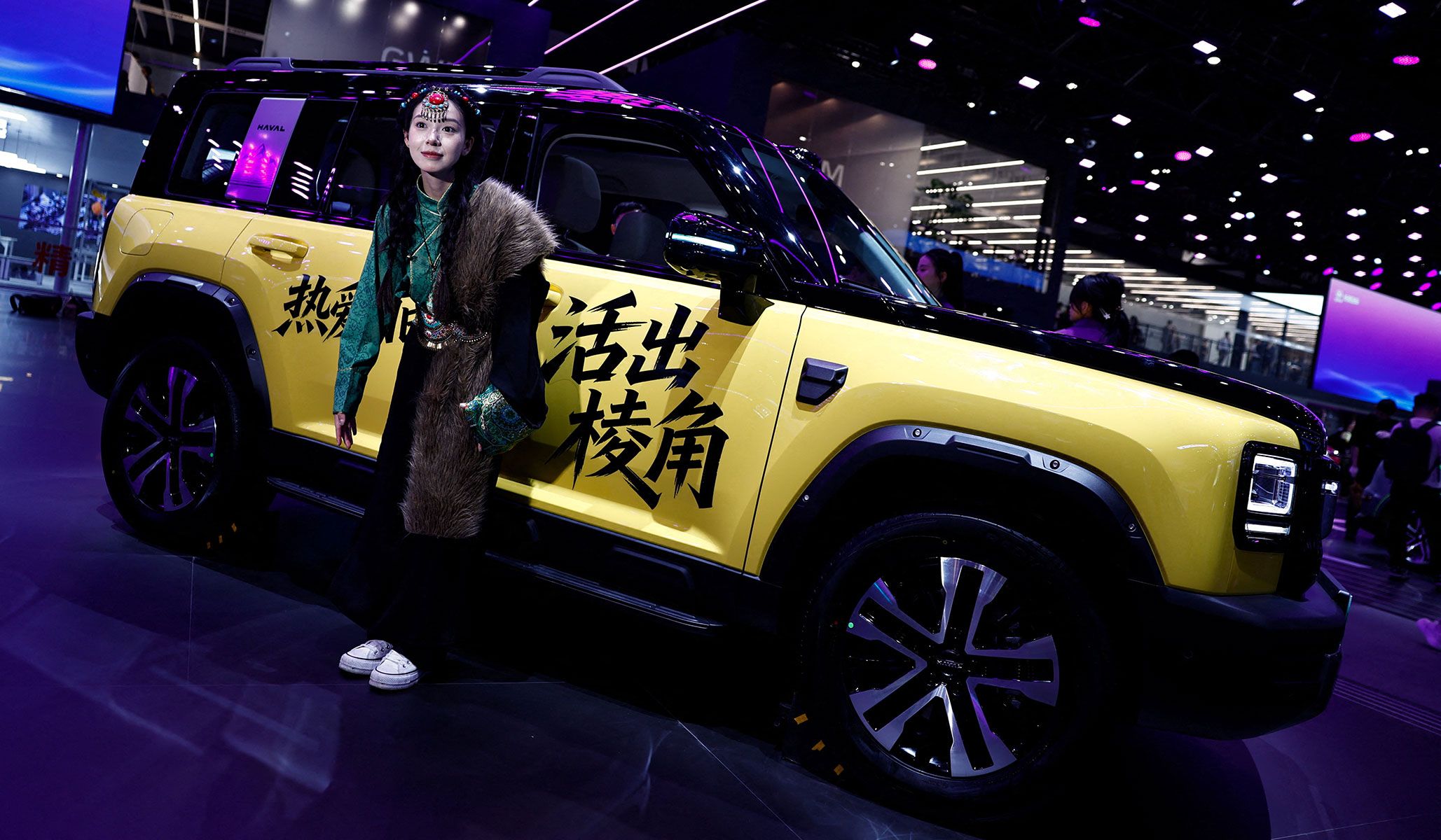 A woman poses during a filming session to promote the Great Wall Motors Haval Raptor Plus SUV at the Beijing International Automotive Exhibition in Beijing, China, April 24, 2026.
