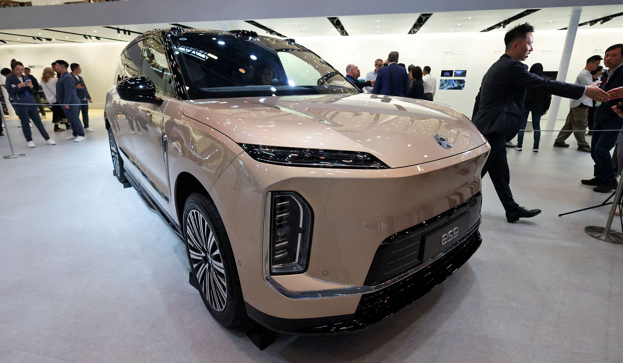 People gather next to the newly presented flagship SUV EV model ES9 by Chinese electric car maker NIO at the Beijing International Automotive Exhibition in Beijing, China, April 24, 2026.