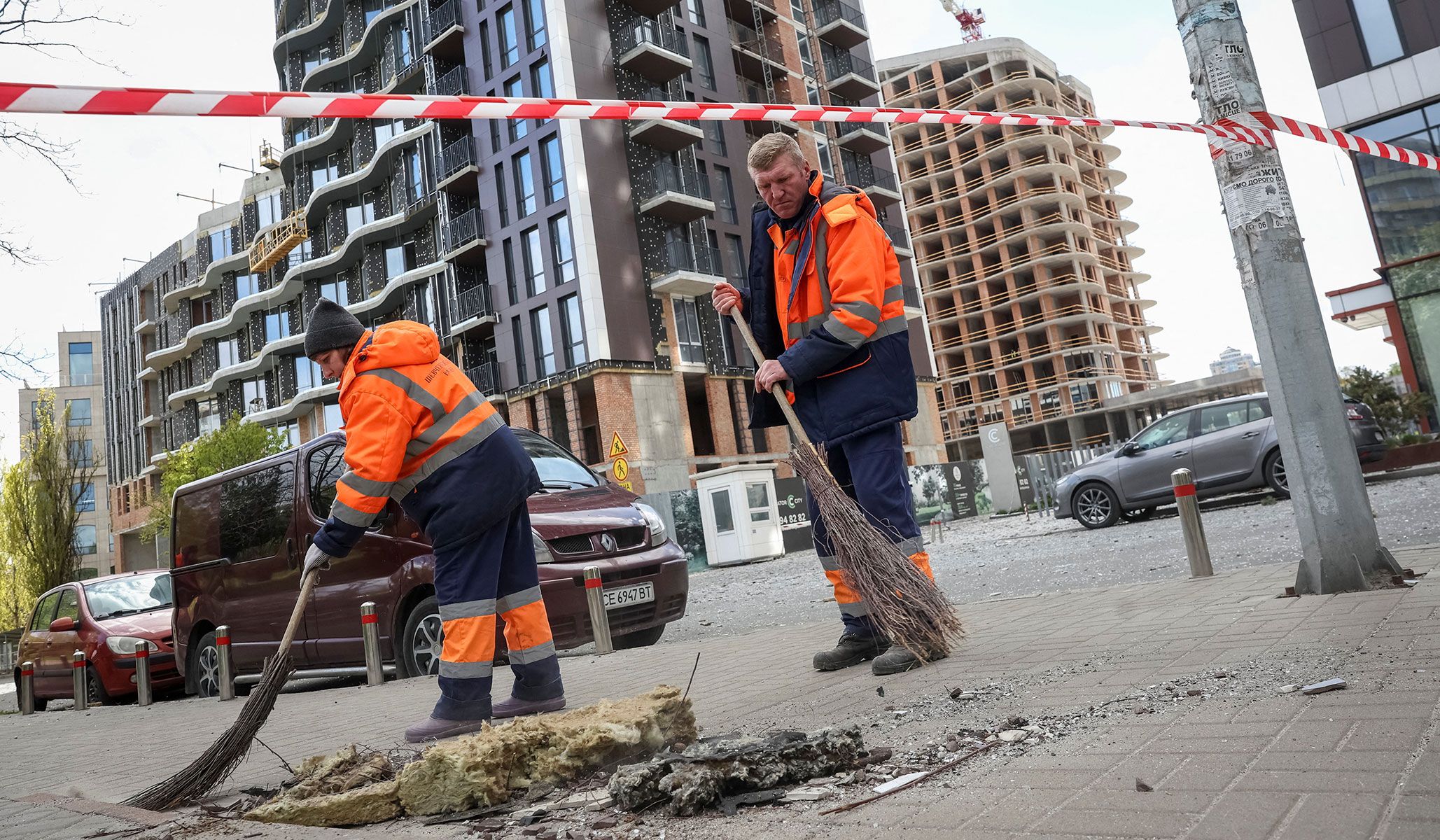Communal workers clean an area at a site of a Russian drone strike in Kyiv, Ukraine, April 28, 2026.
