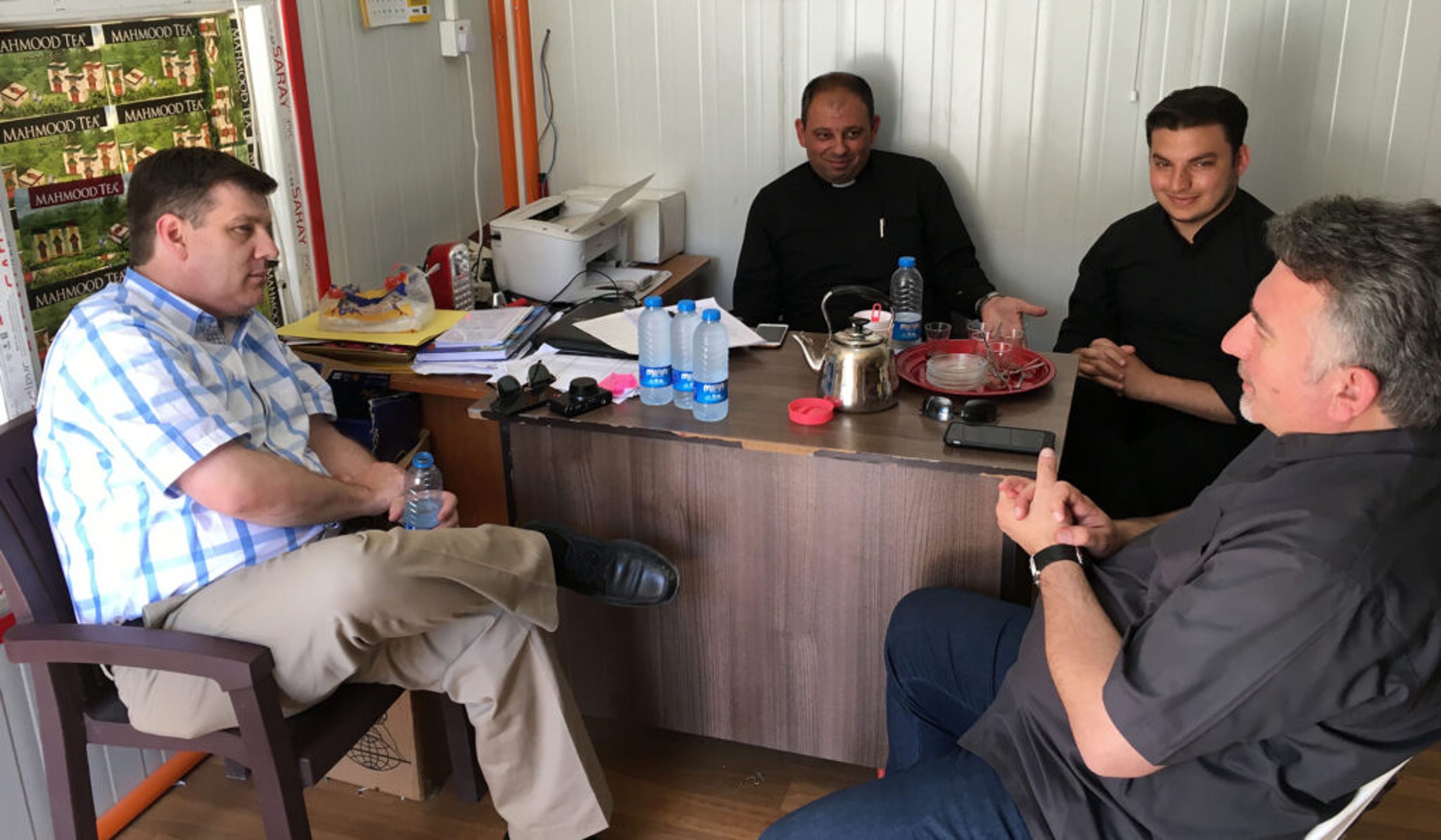 Andrew Walther (left) in a meeting with the priests in the displaced persons camp for the people from Karamles, in Iraq, 2016. From left: Walther, Fr. Thabet Habib (now Msgr Thabet), Fr. Martin Banni, and Fr. Douglas Bazi.