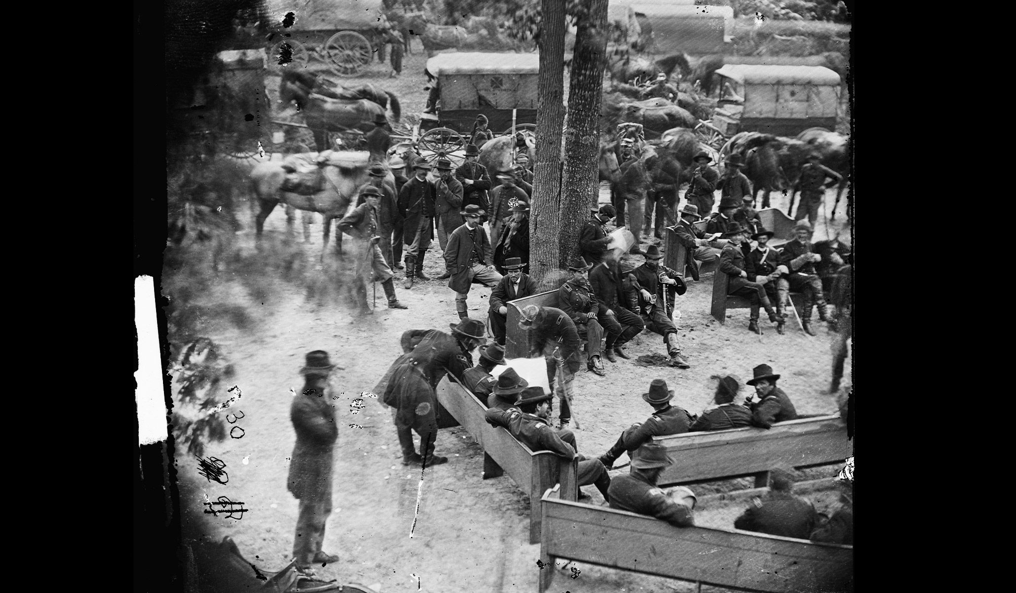 General Ulysses S. Grant (leaning over bench, lower left) examines a map held by General George G. Meade in Massaponax Church, Va., May 21, 1864.