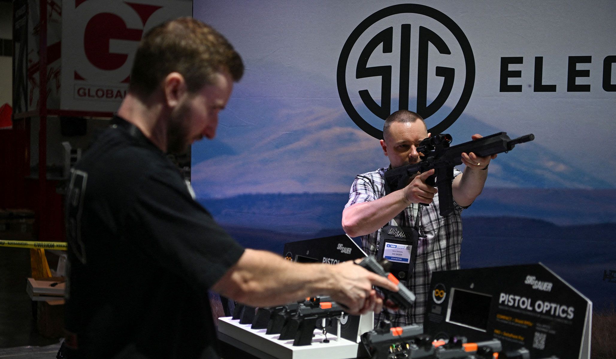 Exhibitors handle guns as they set up a booth ahead of the National Rifle Association's annual meetings and exhibits in Houston, Texas, April 16, 2026.