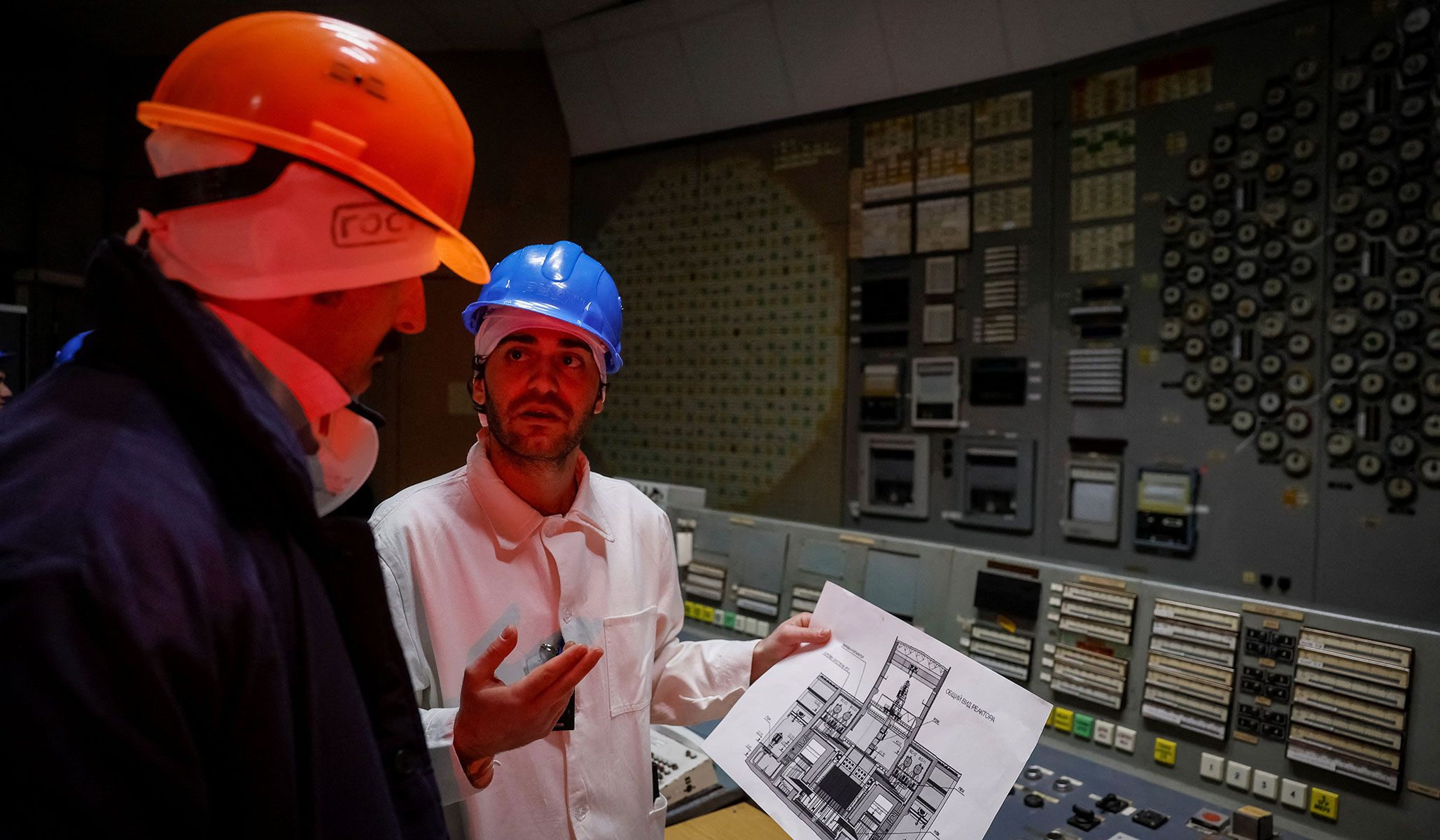 An employee speaks with a journalist in a control center of the stopped third reactor at the Chernobyl nuclear power plant in Kyiv Region, Ukraine, April 22, 2026.