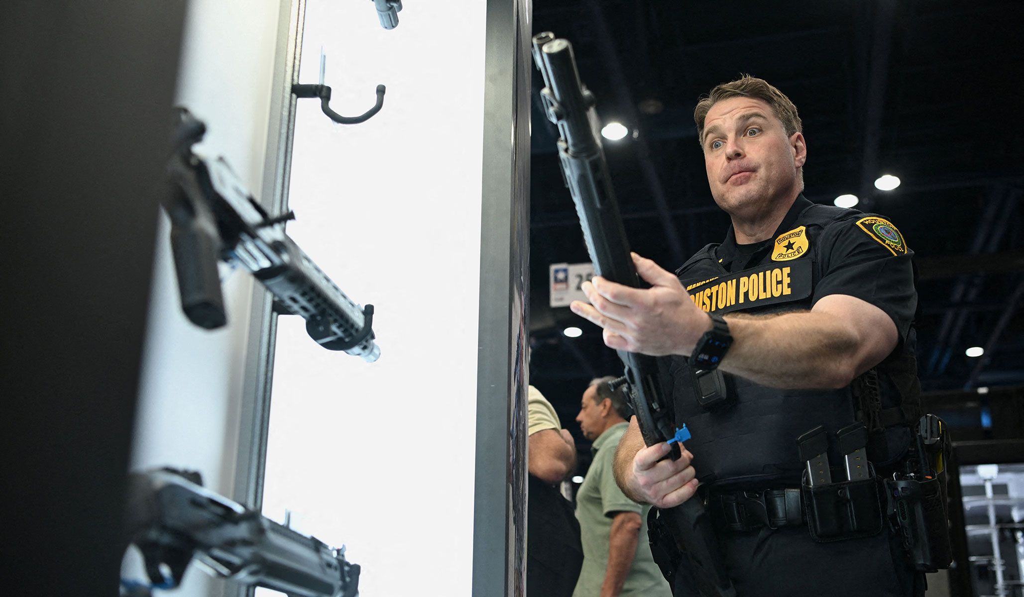 A member of the Houston Police Department holds a gun on display as people attend the National Rifle Association's annual meetings and exhibits in Houston, Texas, April 17, 2026.